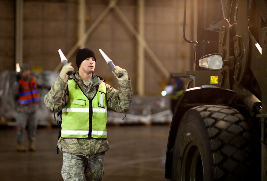 Airman 1st Class Alex Russell marshalls a 10,000-pound forklift in Hangar 949 during an operational readiness exercise Jan. 28, 2010, at Misawa Air Base, Japan. Forklift operators used spotters and marshallers to ensure they were able to see what was around them at all times. (U.S. Air Force photo/Staff Sgt. Samuel Morse) 
