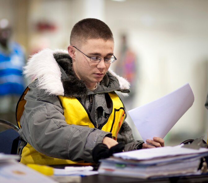 Airman 1st Class Joshua Buck, 35th Operations Support Squadron airfield operations management coordinator, sorts through pallet measurements paperwork inside Hangar 949 during an operational readiness exercise Jan. 28, 2010, at Misawa Air Base, Japan. These measurements allow cargo aircraft loadmasters to precisely balance their aircraft for efficient flight. (U.S. Air Force photo/Staff Sgt. Samuel Morse)