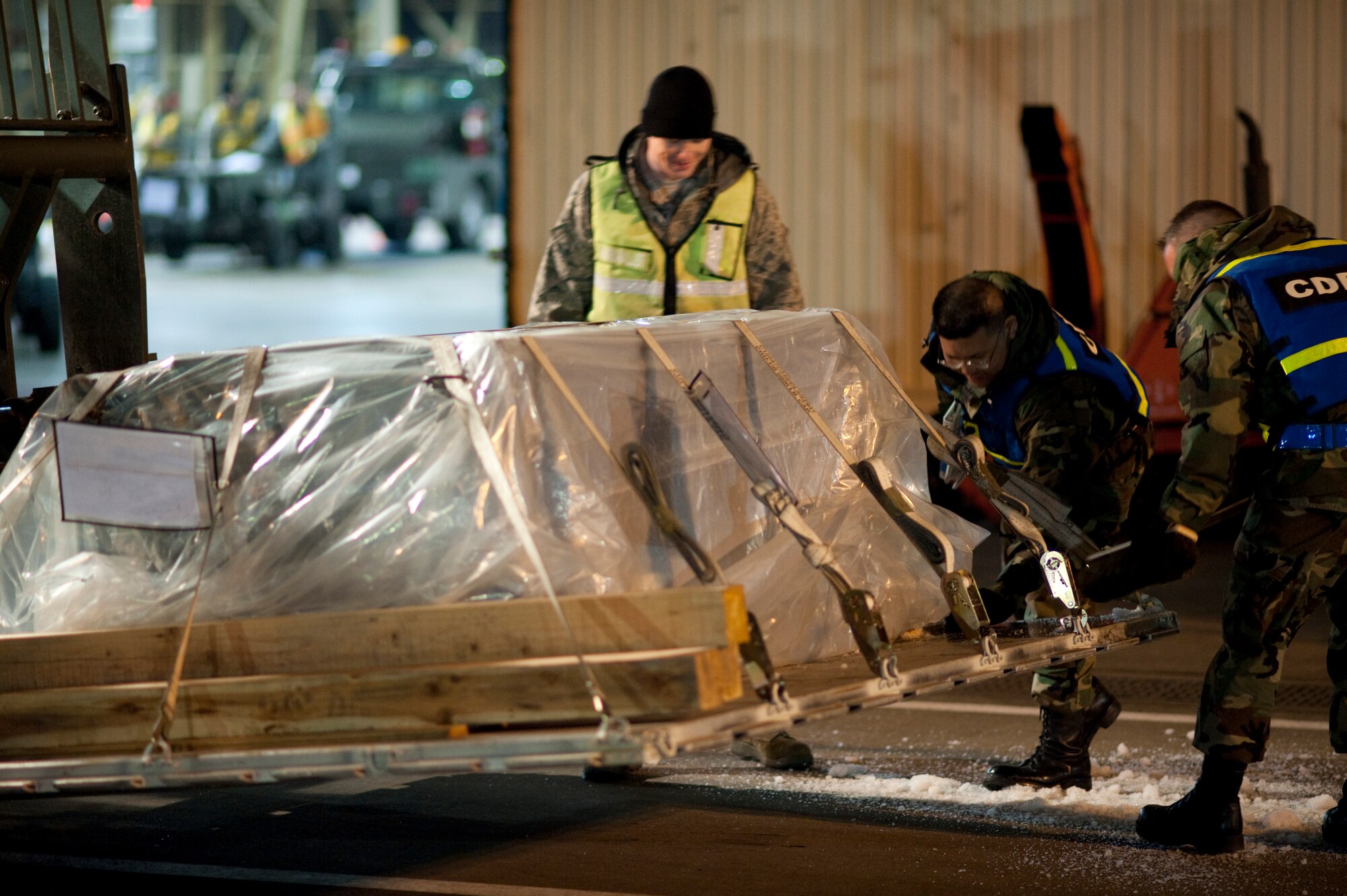 MISAWA AIR BASE, Japan -- Airman 1st Class Alex Russell, Staff Sgt. Travis Baker and Staff Sgt. Ronald Stoll brush ice and snow off of an aircraft pallet outside Hangar 949 during an operational readiness exercise Jan. 28. The snow had to be removed in order to get an accurate weight for flight. (U.S. Air Force photo/Staff Sgt. Samuel Morse)