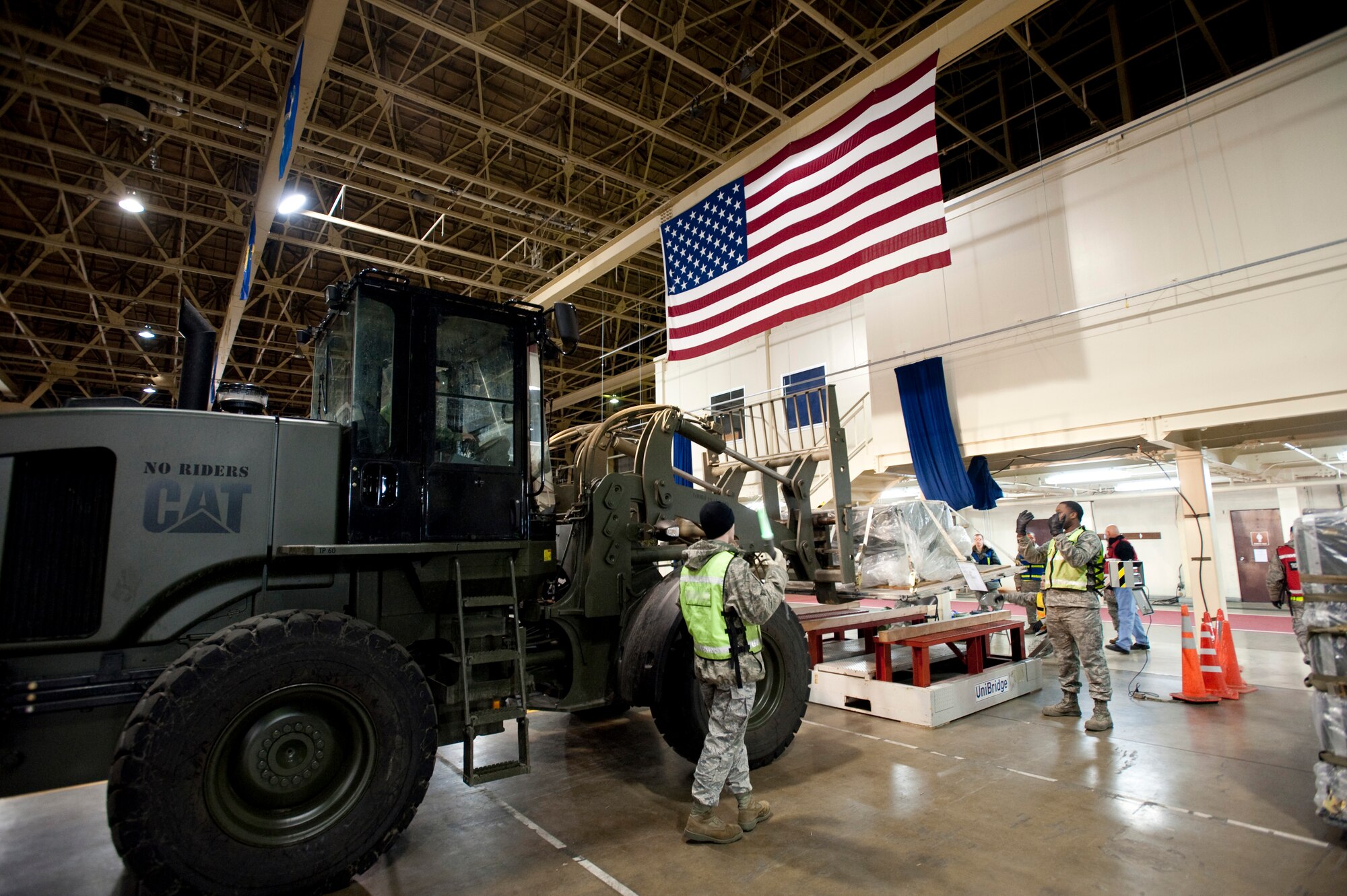 MISAWA AIR BASE, Japan -- Airman 1st Class Alex Russell marshalls a 10,000-pound forklift to set an aircraft pallet onto a scale inside Hangar 949, Jan. 28. Members of the 35th Logistics Readiness Squadron measure the weight and dimensions of each pallet to help aircraft loadmasters determine where to put them on an aircraft. (U.S. Air Force photo/Staff Sgt. Samuel Morse)