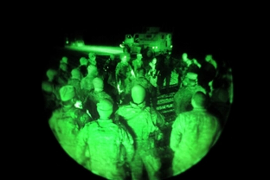 As seen through a night-vision device, Provincial Reconstruction Team members conduct a role call for a three-day mission from Forward Operating Base Farah, Afghanistan, to Herat and back, Jan. 30, 2010. The mission's goal is to retrieve four new mine-resistant, ambush-protected vehicles in Heart and convoy back to the base. The MRAPs, with their “V”-shaped hull design, will offer greater protection for the team members and passengers against roadside bombs.
