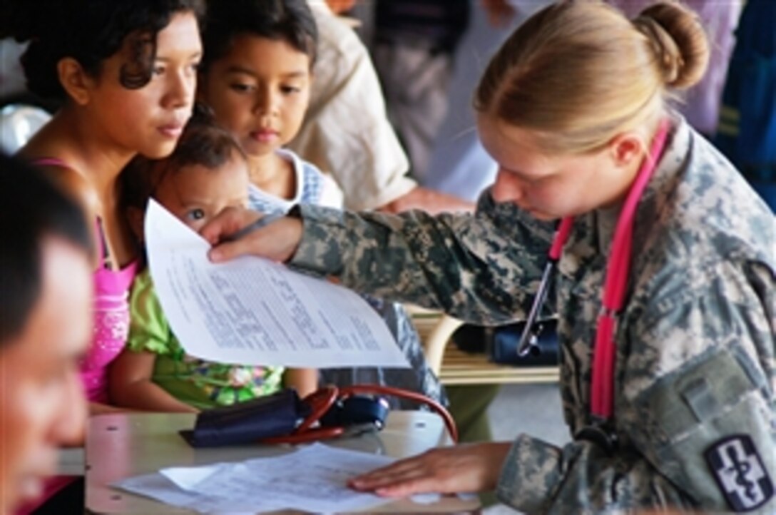 U.S. Army Spc. Felicia Chadwick checks vital signs of members of a Salvadoran family at a  treatment site in Guadalupe, El Salvador, Fed. 3, 2010. Chadwick is a medical specialist assigned to the 420th Minimal Care Detachment in Polar Bluff, Mo. 