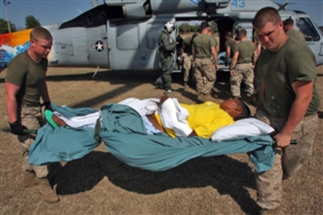 U.S. Marines and sailors move three Haitian patients from a MH-60 in Port-au-Prince, Haiti, Feb. 5, 2010. The patients were transported from the USNS Comfort and received immediate medical care upon arrival at the interim aftercare facility in Port-au-Prince. The U.S. troops are assigned to Combat Logistics Battalion 24, 24th Marine Expeditionary Unit. 