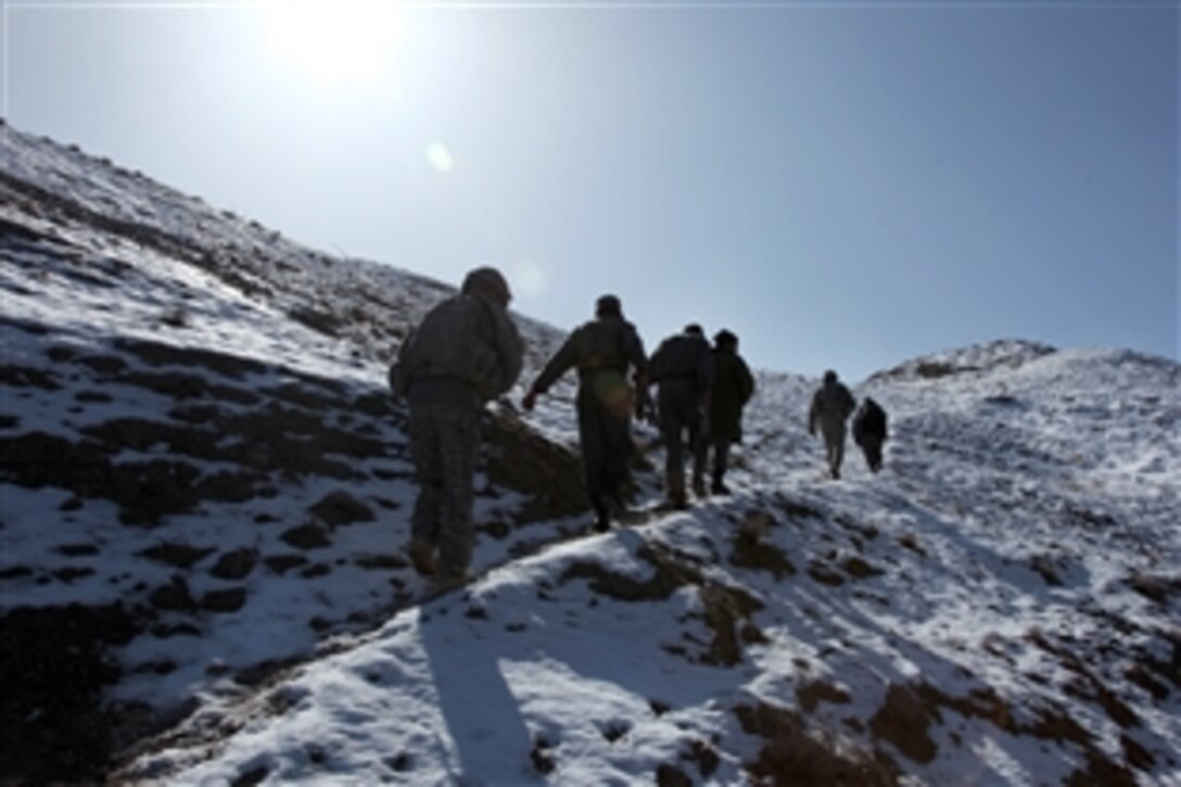 U.S. soldiers and Afghan police officers walk up a hill on their way into the village of Mongow Khel in Logar province, Afghanistan, Feb. 2, 2010. They are meeting with the Mongow Khel elders to ensure good relationships with residents and to see if everything is going well in the area. The U.S. soldiers are assigned to the 118th Military Police Company based in Fort Bragg, N.C.