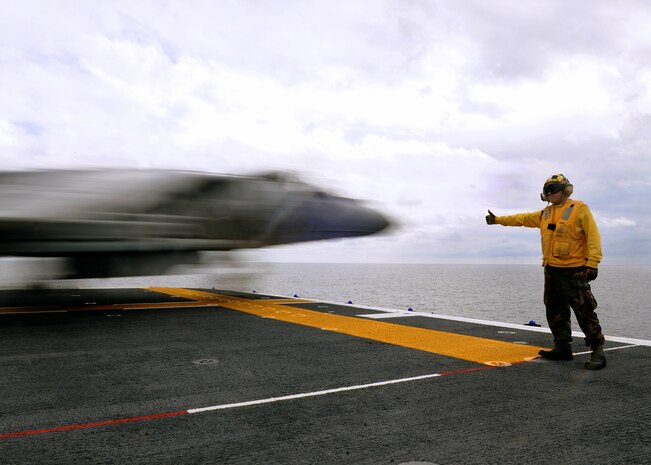 Seaman Ryan Bain, aircraft handler, signals the go-ahead for Capt. Michael Lippert, Marine Attack Squadron 311 pilot, as he launches off the flight deck of the USS Peleliu during the squadron’s aircraft carrier qualifications Feb. 9, 2010. Approximately 10 pilots and 15 support and maintenance personnel participated in the exercise. The squadron practiced Harrier operations aboard the aircraft carrier from Feb. 8-11, including night flights, in preparation for the squadron’s upcoming deployment aboard the Peleliu with the 15th Marine Expeditionary in May.