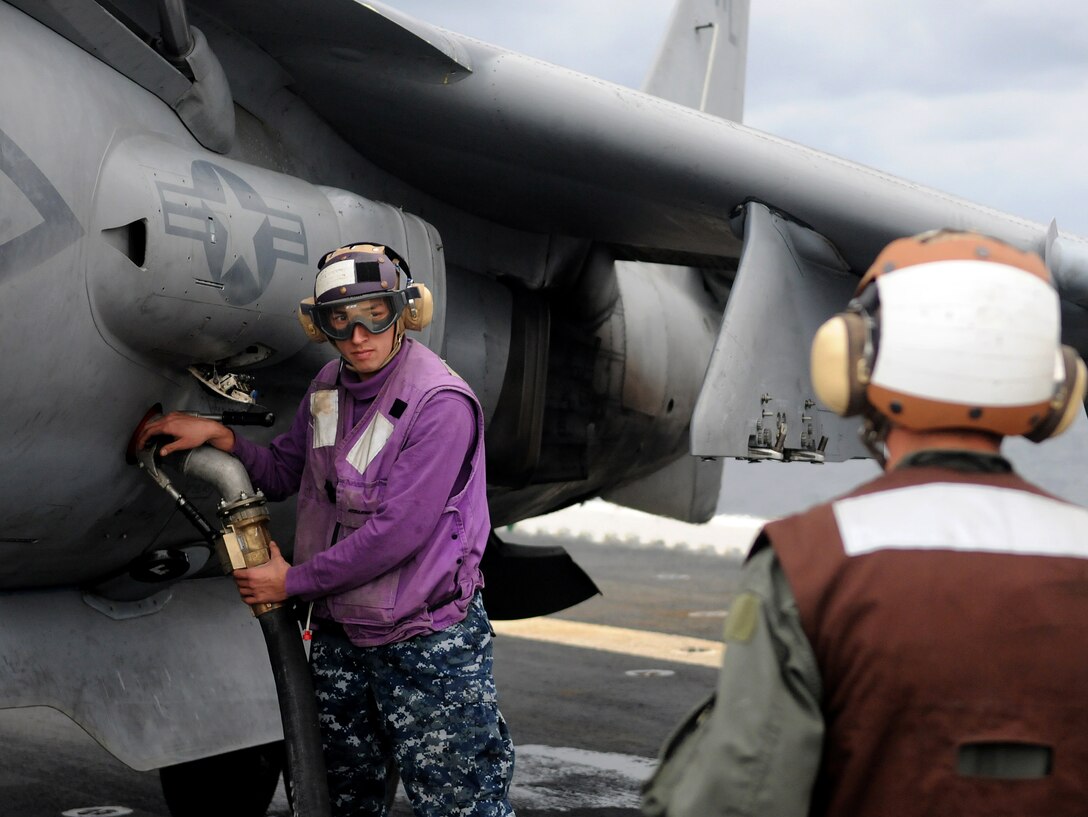 Cpl. Dale Okkerse, right, Marine Attack Squadron 311 powerline mechanic, oversees Seaman Russell Hoyt, aviation fuel specialist for the USS Peleliu, as he refuels one of the squadron’s AV-8B Harriers Feb. 9, 2010, during the squadron’s aircraft carrier qualifications aboard the Peleliu. Approximately 10 pilots and 15 support and maintenance personnel participated in the exercise. The squadron practiced Harrier operations aboard the aircraft carrier from Feb. 8-11, including night flights, in preparation for the squadron’s upcoming deployment aboard the Peleliu with the 15th Marine Expeditionary in May. “One thing about training on the carrier is that it’s not just the pilots that are getting trained, but the maintainers and sailors as well,” said Capt. Eric Fong, squadron pilot.