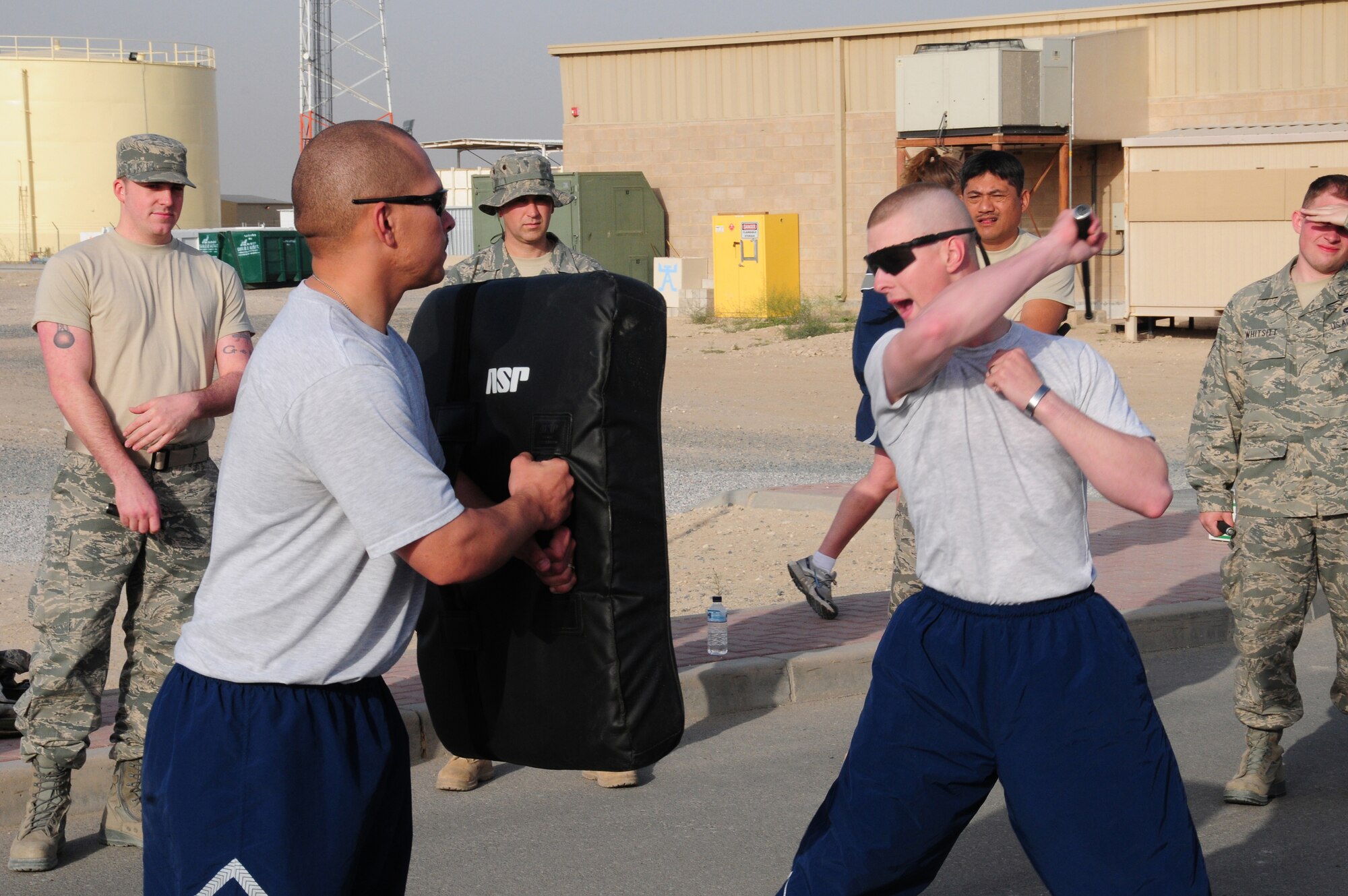U.S. Air Force Staff Sgt. Matthew Heenan, left, and Senior Airman Joshua Dillman, both members of the 386th Expeditionary Security Forces Squadron Force Protection flight, demonstrate the proper stance and strike technique during a force protection asp training session Feb. 9, 2010 at an air base in Southwest Asia. The course is designed to prepare Airmen to handle any hostile situation that may arise during their time downrange. (U.S. Air Force photo by Staff Sgt. Lakisha A. Croley/Released)