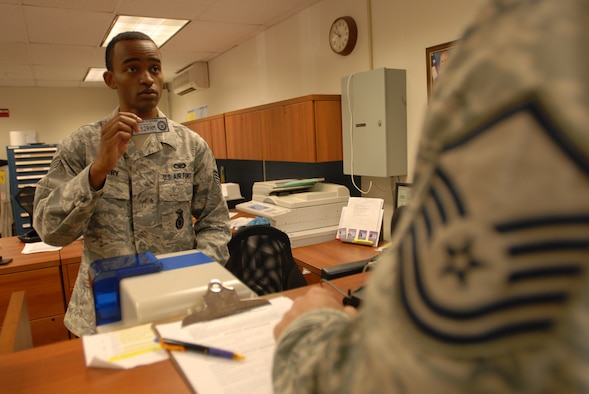Staff Sergeant Devone Cherry, 15th Security Forces Squadron Pass and Registration Assistant NCO-in-charge, issues a base decal to a customer at Pass and ID here, Feb. 10. Car decals became mandatory for anyone entering Joint Base Pearl Harbor Hickam Feb. 1. To get decals, customers must have a state of Hawaii registration or completed DF-L-27, Hawaii safety inspection certificate (pink or yellow copy), Hawaii insurance card, state or international driver's license and a Department of Defense identification card. Motorcyclists must additionally provide a motorcycle safety course card. 