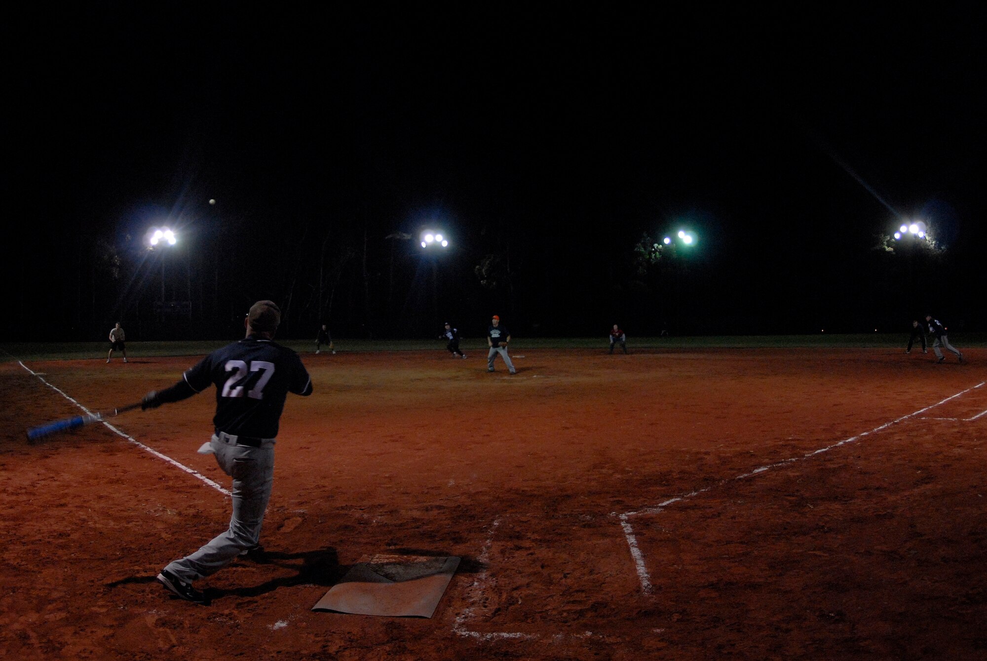 VANDENBERG AIR FORCE BASE, Calif. -- Sending the ball through the air, Steve Dewese, of the 576th Flight Test Squadron’s intramural softball team, earns a run to first base during a match-up against the 30th Space Communications Squadron at the base softball field here Thursday, Feb. 4, 2010.  The 576th FLTS shut-out the 30th SCS 19-0. (U.S. Air Force photo/Senior Airman Andrew Satran) 
