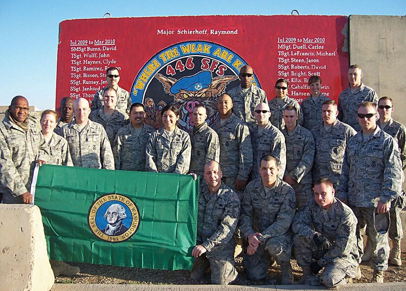 Reservists from the 446th Security Forces Squadron, Joint Base Lewis-McChord, Wash., stand in front of a mural at Kirkuk Air Base, Iraq before returning home from a recent six-month deployment in support of Operation Iraqi Freedom. With a little help from his friends, Tech Sgt. John Wulff created the mural to honor the dedication of the 23 members who were part of this deployment. It was the largest group of 446th SFS Reservists deployed at one time. (U.S. Air Force photo/Senior Master Sgt. David Burns)