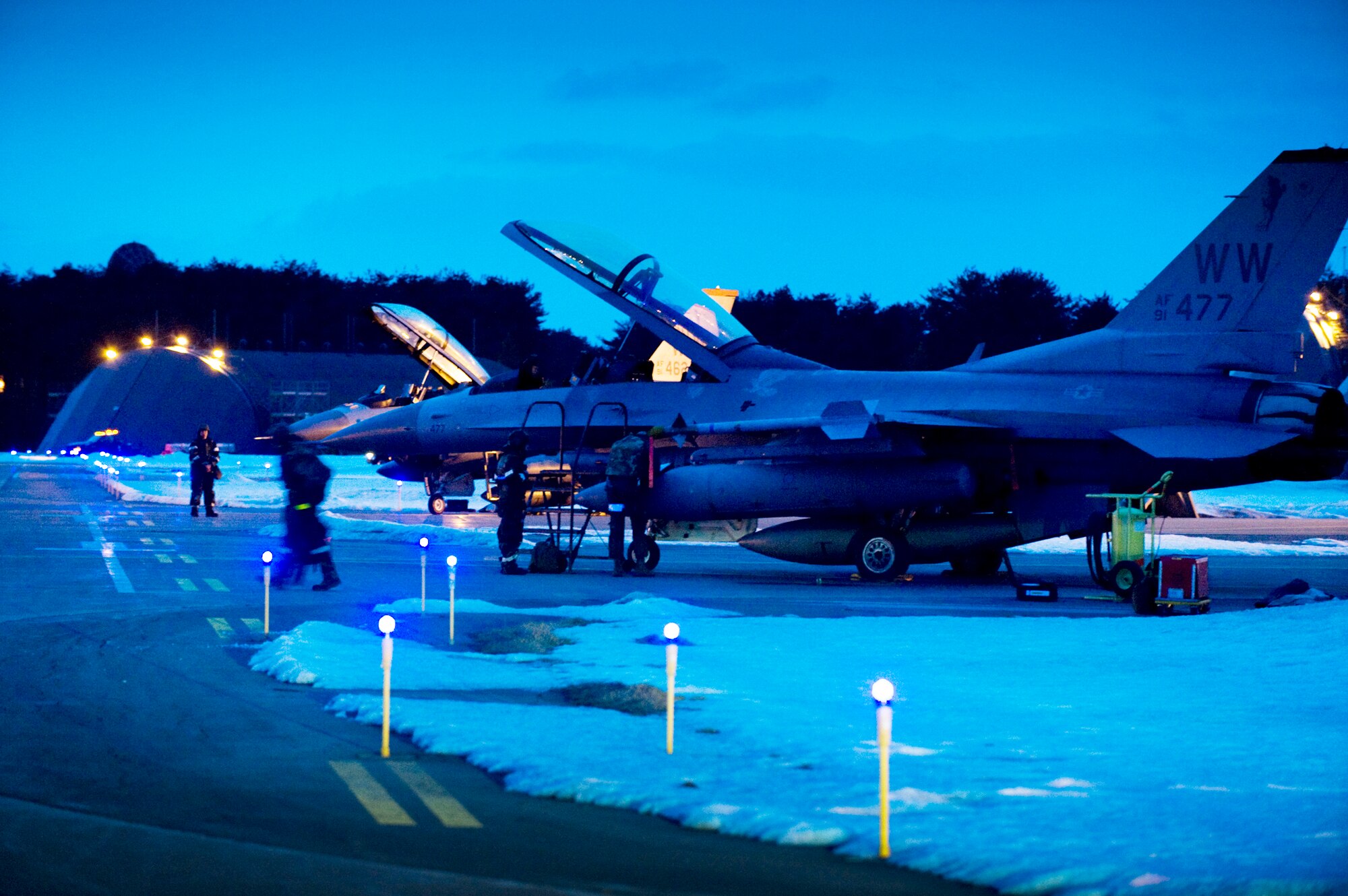 Maintenance crews ready two F-16 Fighting Falcons on the flightline at Misawa Air Base, Japan, for flight during an operational readiness exercise Feb. 1, 2010. These dual-seat models were used as aggressor aircraft to test pilots on how to evade or engage enemies. (U.S. Air Force photo/Staff Sgt. Samuel Morse)