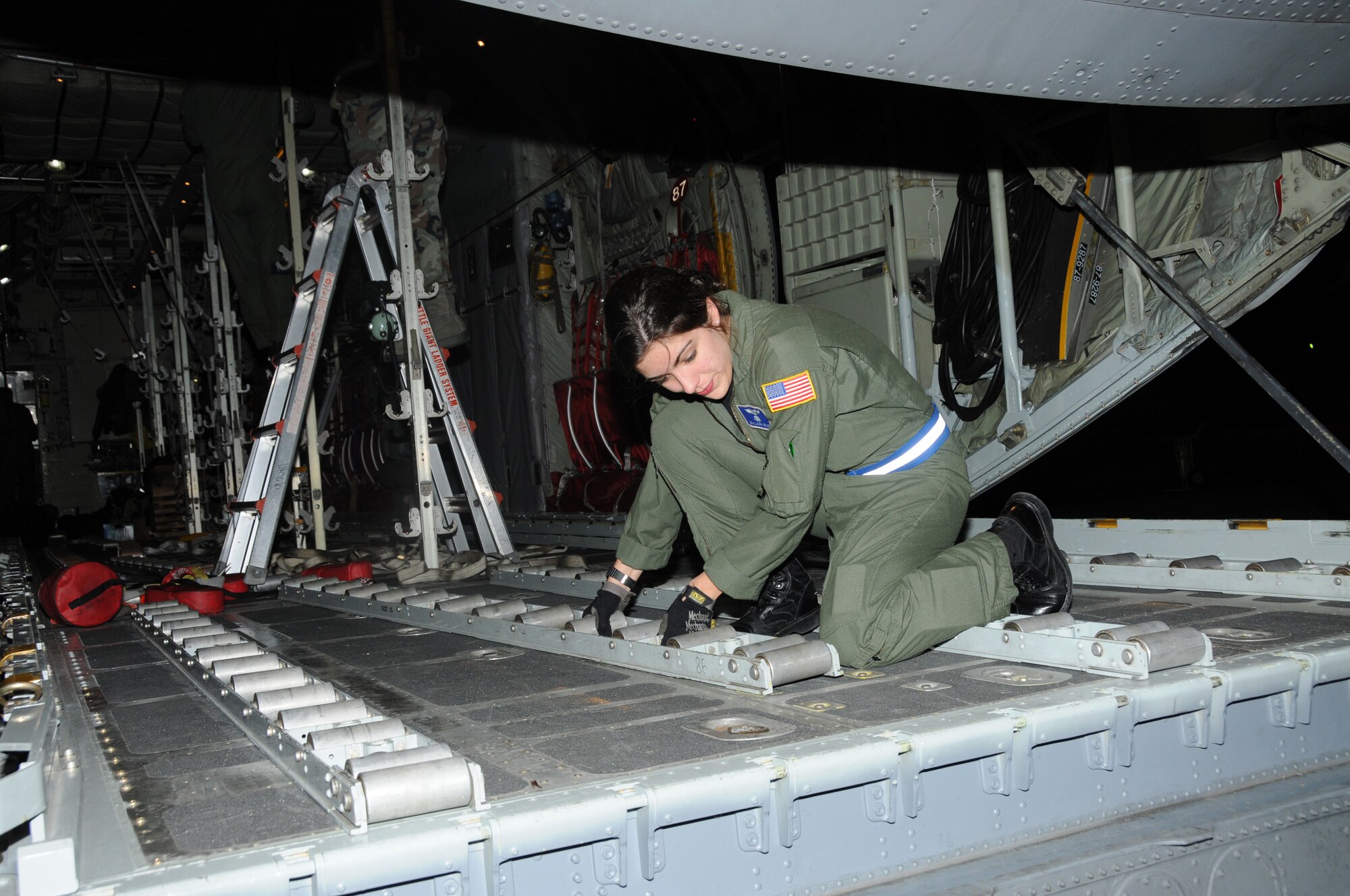 Senior Airman Laura Kruse installs rollers in preparation for the pallets of water that are to be loaded. The Airman along with other crew members prepare the C-130 to pick up a load of bottled water destine for Haiti. The 107th has provided crews along with aircraft for the transportation of supplies into and evacuees out of Haiti since four days after the earthquake hit. (U.S. Air Force photo/Staff Sgt. Peter Dean)