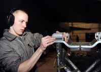 MINOT AIR FORCE BASE, N.D. -- Airman 1st Class Kyle Herman, 5th Aircraft Maintenance Squadron armament systems team member, applies bomb rollers on an MJ-1 Jammer here during a load crew of the quarter competition here Feb. 5. Load crew competitions build camaraderie and ensure weapons Airmen maintain proficiency. (U.S. Air Force photo by Senior Airman Sharida Jackson)
