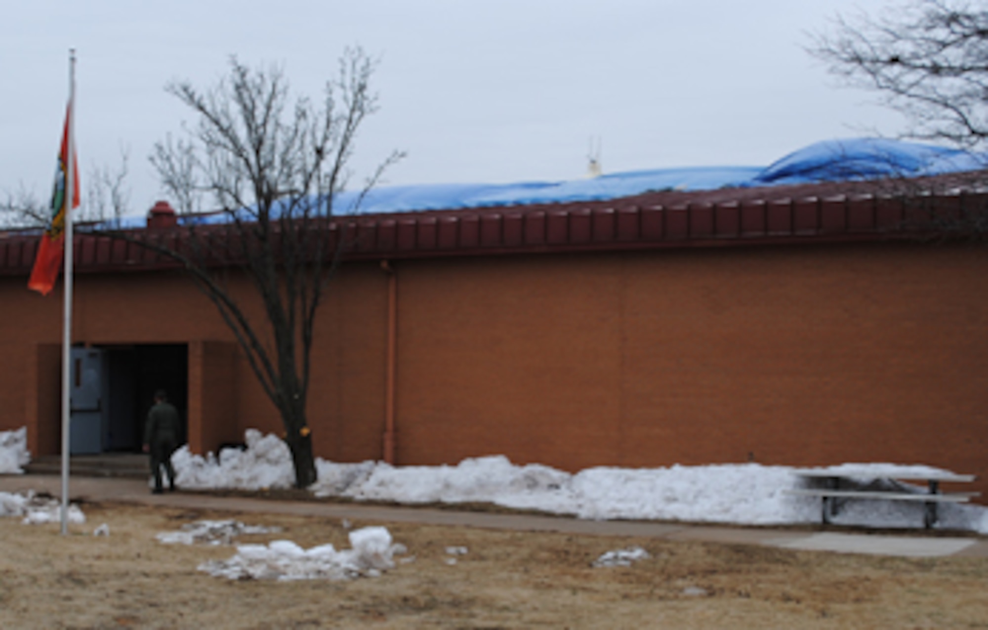 Tarps cover the section of roof on Bldg. 179 that collapsed following the winter storm that closed the base Jan. 28-29. Civil Engineers have sealed the roof temporarily until permanent repairs can be made. (U.S. Air Force photo/ Ensign Rex Miller)