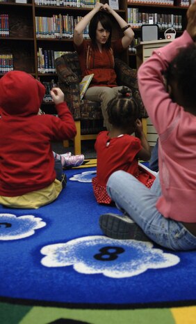 Sarah Sherrill leads a group of children in singing "Grandpa's Glasses" during the Valentine's Day Story Hour at the base library here Feb. 9. Story hour is held once a week on Tuesdays for spouses and their children. Mrs. Sherrill is a library technician with the Joint Base Charleston Library. (U.S. Air Force Photo/Airman 1st Class Lauren Main)