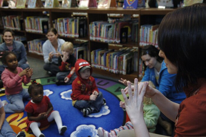 Sarah Sherrill leads a group of children in singing "The Itsy, Bitsy Spider" during the Valentine's Day Story Hour at the base library here Feb. 9. Following the story hour, the children made valentines and ate cupcakes. Story hour is held once a week on Tuesdays for spouses and their children. Mrs. Sherrill is a library technician with the Joint Base Charleston Library. (U.S. Air Force Photo/Airman 1st Class Lauren Main)