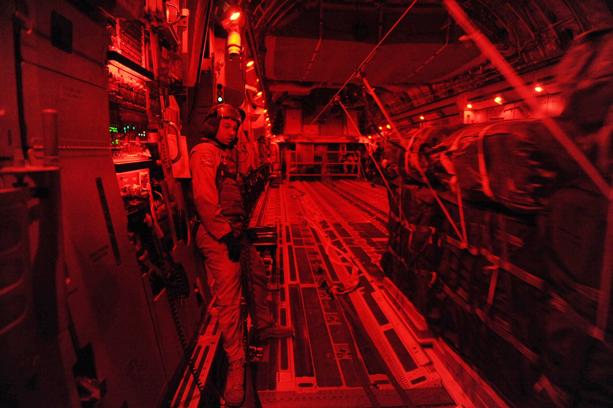 Over a forward operating base in Afghanistan, Staff Sgt. Russell C. Johnson makes sure 40 container delivery system bundles of food and water slide off a C-17 Globemaster III cargo ramp Feb. 1, 2010. He is a C-17 loadmaster assigned to the 816th Expeditionary Airlift Squadron.  (U.S. Air Force photo/Staff Sgt. Manuel J. Martinez)