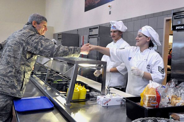Air Force Chief of Staff Gen. Norton Schwartz meets Airman First Class Michael Gurski (center) and shakes hands with Staff Sgt. Betsy Ulyak, both from the 27th Special Operations Force Support Squadron, during lunch at the dining facility Jan. 26. General Schwartz had lunch with numerous Airmen from around Cannon Air Force Base, N.M. (U.S. Air Force photo by Staff Sgt. Heather R. Redman) 
