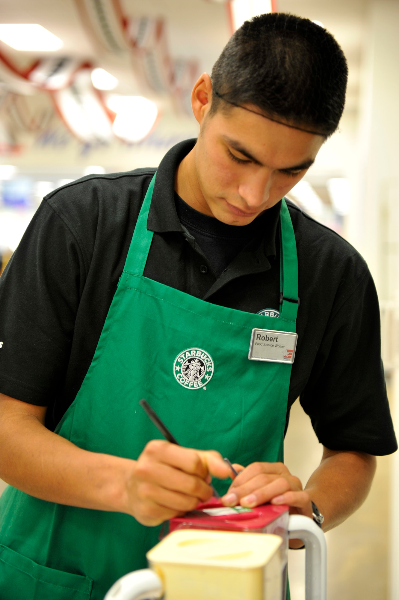 Robert Gillard, food court employee, writes the date and time on cold drinks Feb. 5 at the new Base Exchange to ensure all health codes are met. Starbucks is one of many new restaurant establishments being offered at the new Food Court. (U.S. Air Force photo by Senior Airman Christine Clark)