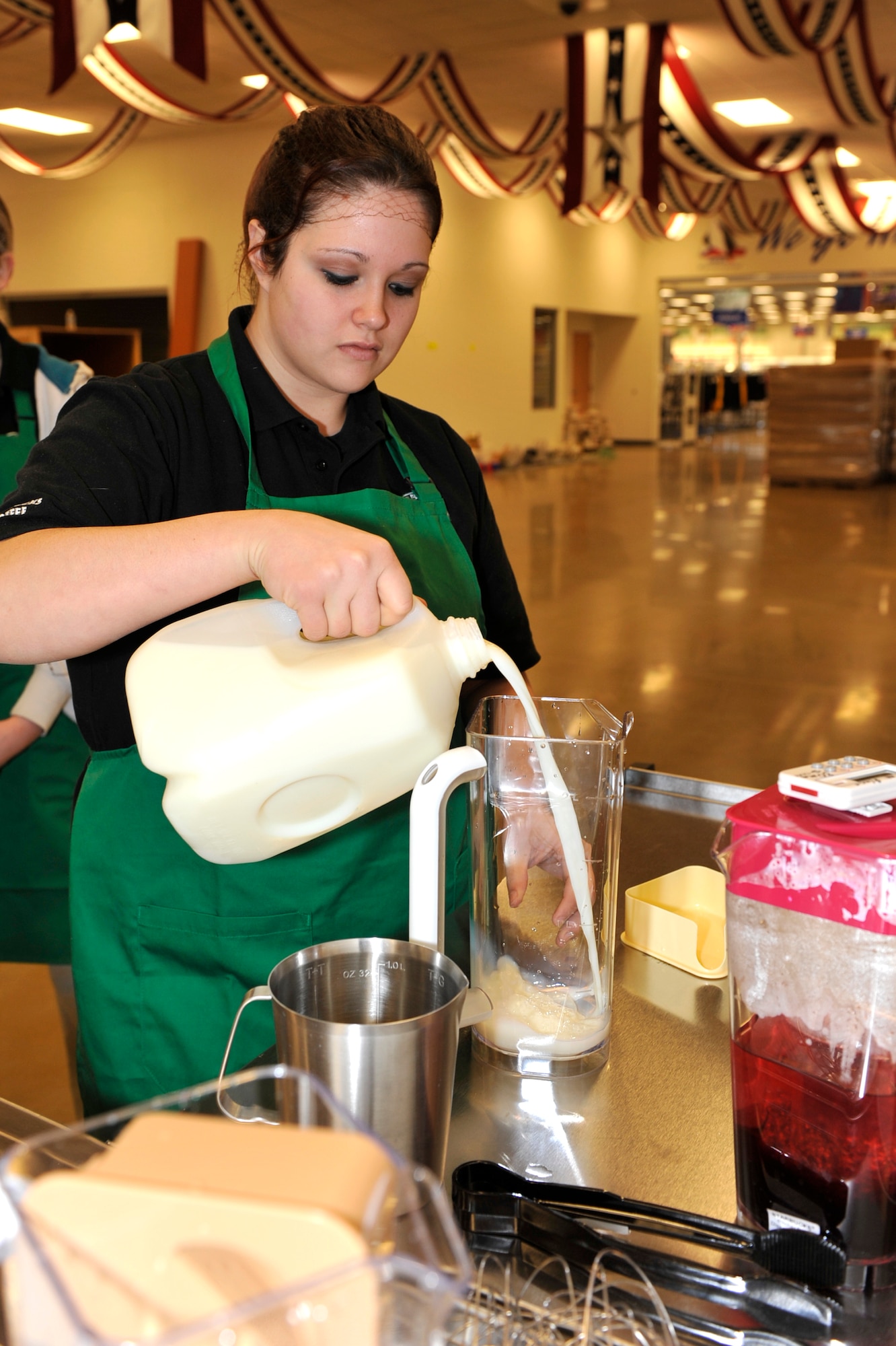 Stevie Johnson, food court employee, pours milk Feb. 5 to make a signature Starbucks drink at the new Base Exchange Food Court. With the new grand opening fast approaching, many of the employees are going through training and preparation. (U.S. Air Force photo by Senior Airman Christine Clark)