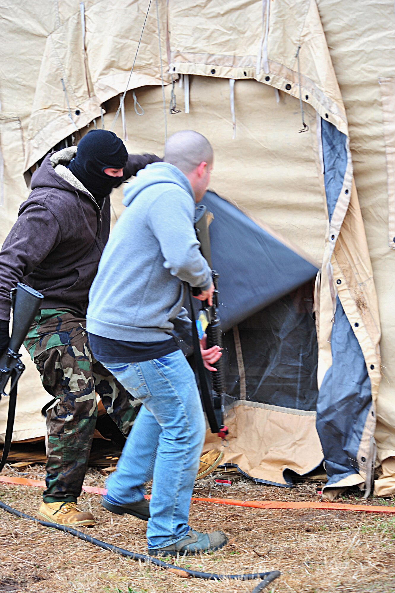 SHAW AIR FORCE BASE, S.C. -- Staff Sgt. Ferdinando Acerra (left), 20th Maintenance Operations Squadron, and Airman 1st Class Benjamin Marconi, 20th Operations Support Squadron, both members of the exercise evaluation team, simulate an attack on a tent in the fictional deployed location during the phase II operational readiness exercise here Feb. 9. The EET is responsible for aiding in the setup, supervision and grading of training scenarios. Shaw performs routine exercises throughout the year to ensure Airmen are ready for base or deployment attacks. (U.S. Air Force photo/Airman 1st Class Amber E. N. Jacobs)