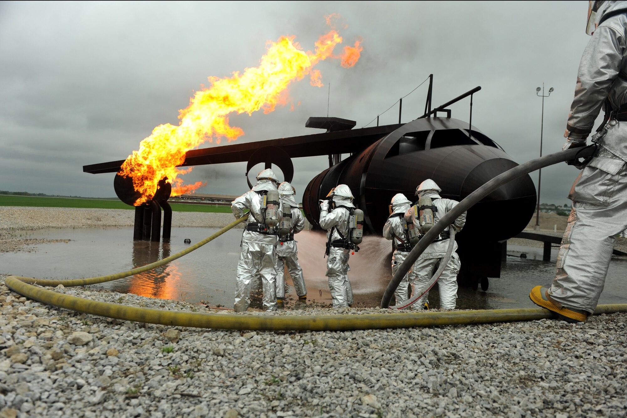 OFFUTT AIR FORCE BASE Neb. - Offutt firefighters extinguish the flames in a simulated aircraft fire trainer during a joint training exercise here May 6. Firefighters from Offutt, Omaha's Eppley airfield and guard and reserve units participated in the training.

U.S. Air Force photo by Josh Plueger