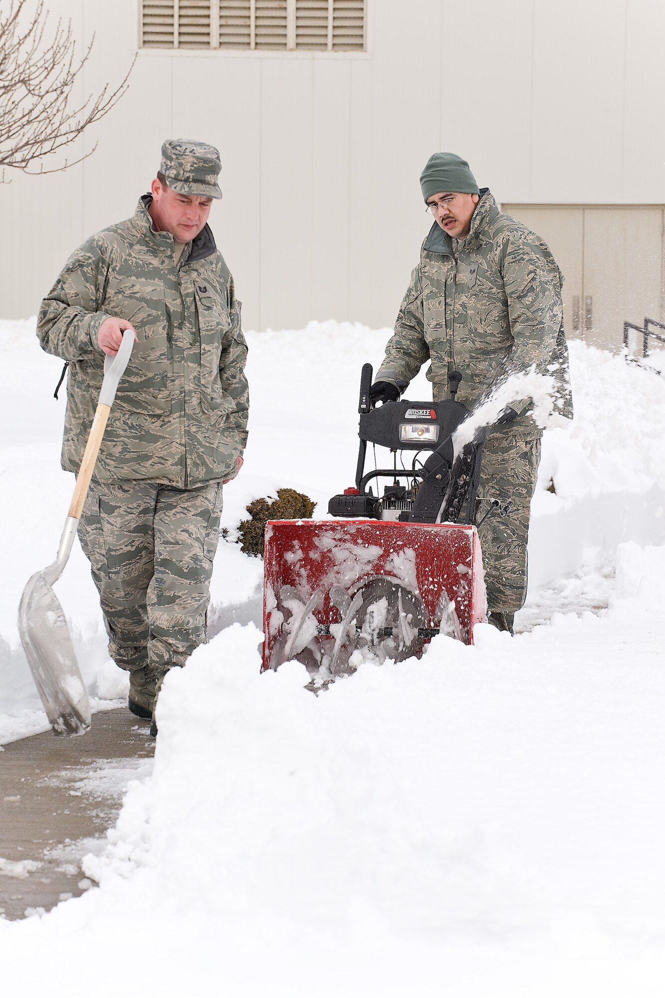 (From left) Tech. Sgt. Eric Broadbent and Staff Sgt. Jorge Fernandez, 436th Logisitics Readiness Squadron, remove snow from in front of Building 639 at Dover Air Force Base Feb. 9.  Team Dover resumed normal operations Feb. 9, and prepared the installation for  a second snow storm forecasted to hit the region Feb. 10. (U.S. Air Force photo/Roland Balik)