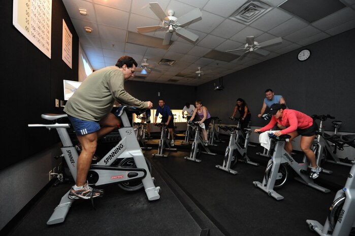 Al Urrutia leads as an instructor for a spin class at the Fitness and Sports Center here Feb. 5, 2010. Spinning is an aerobic exercise that takes place on a specially designed stationary bicycle, allowing individuals to burn excess calories. Mr. Urrutia is an environmental engineer with the 628th Civil Engineer Squadron. (U.S. Air Force photo/James M. Bowman)