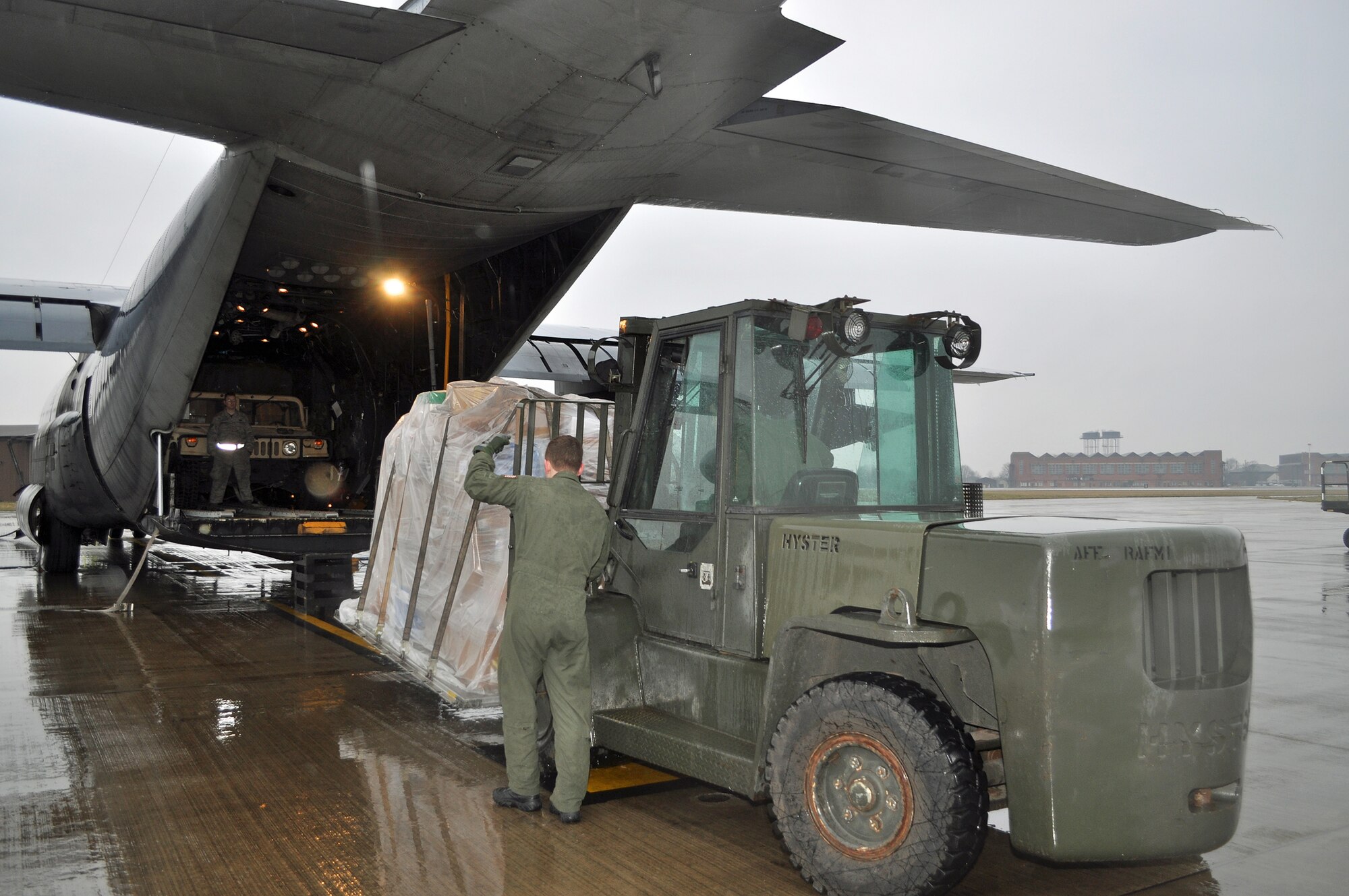 RAF MILDENHALL, England -- Airman 1st Class Anthony Vaticalos, 67th Special Operations Squadron loadmaster, directs a forklift, laden with a pallet of donations for Haiti, into the back of a 352nd Special Operations Group MC-130P Combat Shadow, here, Feb. 5. The 352nd Maintenance Squadron spearheaded a donation effort, collecting about 15,000 pounds of items ranging from toiletries to food to clothing, to assist in Haiti relief efforts.   (U.S. Air Force photo/Tech. Sgt. Marelise Wood)
