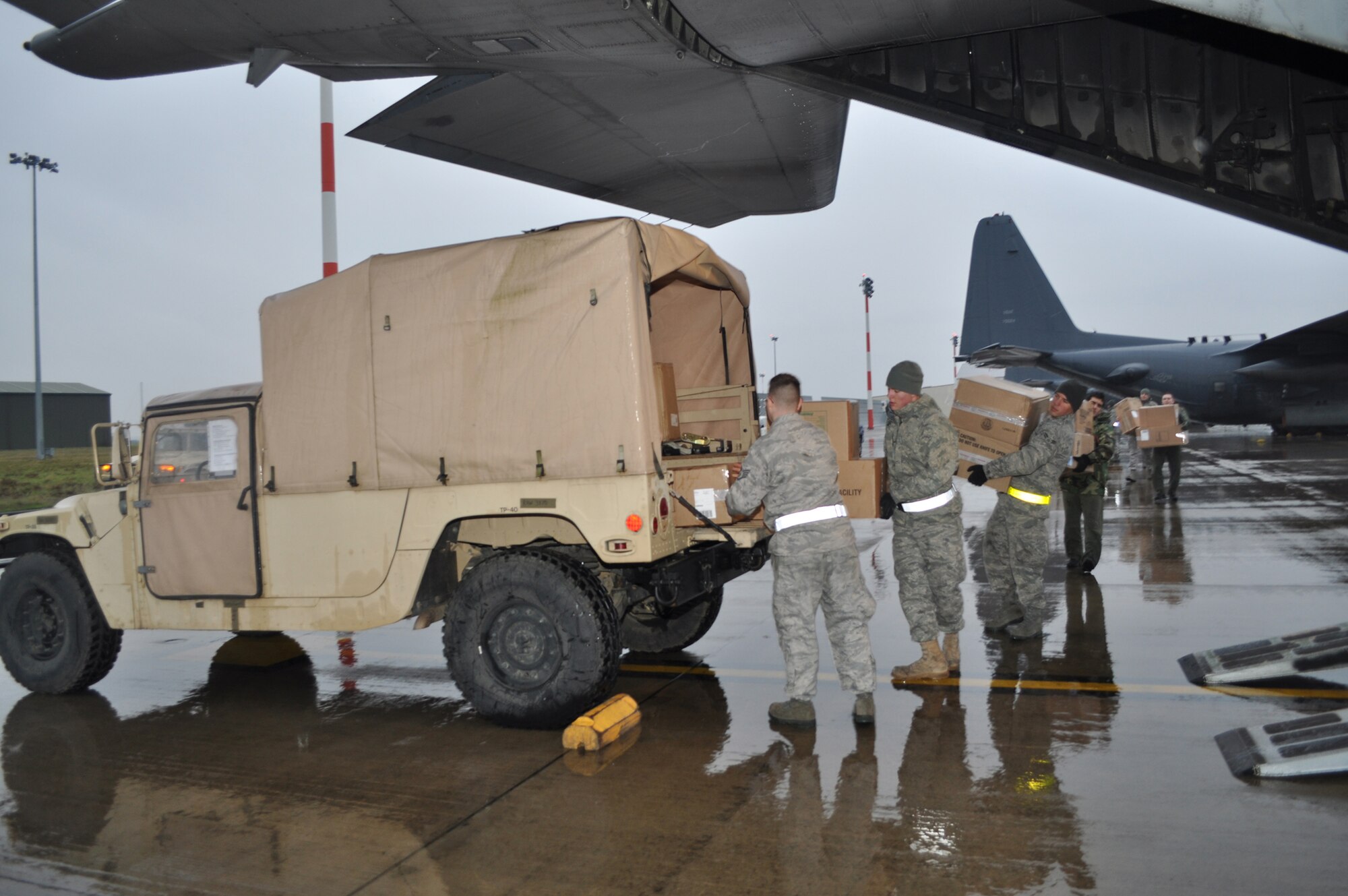 RAF MILDENHALL, England -- Members of the 352nd Special Operations Group pack donations into a Humvee about to be loaded onto an MC-130P Combat Shadow, here, Feb. 5, to aid in the Haiti relief effort.  The 352nd Maintenance Squadron spearheaded a donation effort, collecting about 15,000 pounds of items ranging from toiletries to food to clothing, to assist in Haiti relief efforts.    (U.S. Air Force photo/Tech. Sgt. Marelise Wood)