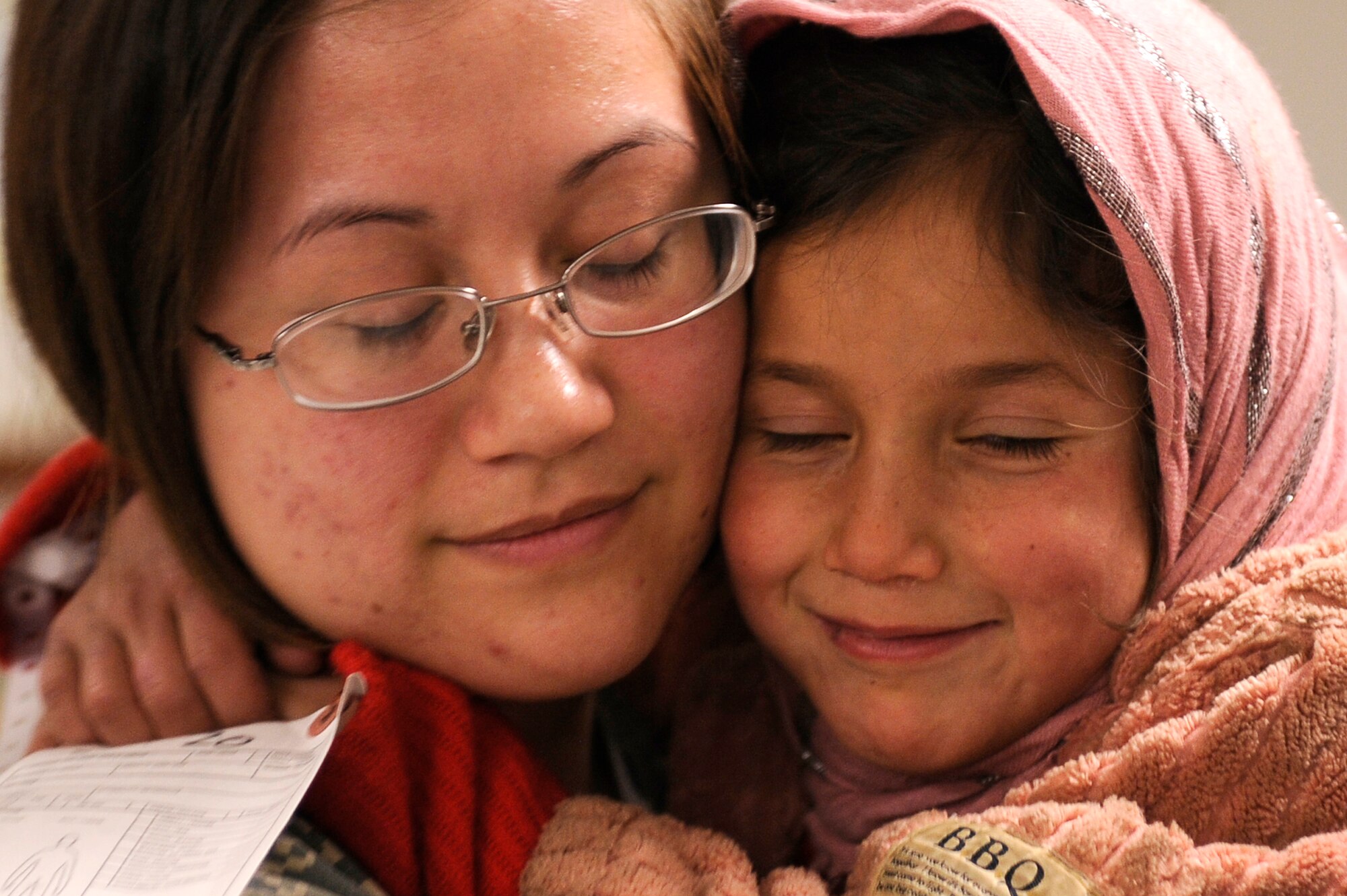 U.S. Air Force Senior Airman Alexandra Benefiel, 455th Expeditionary Medical Group, is hugged by a young avalanche survivor who was medically evacuated to Craig Joint Theater Hospital, Bagram Airfield, Feb. 9, 2010. Dozens of Afghans were taken to Bagram Airfield after an avalanche struck a mountain pass in the Parwan province in north eastern Afghanistan. (U.S. Air Force photo by/ Tech. Sgt. Jeromy K. Cross/released)