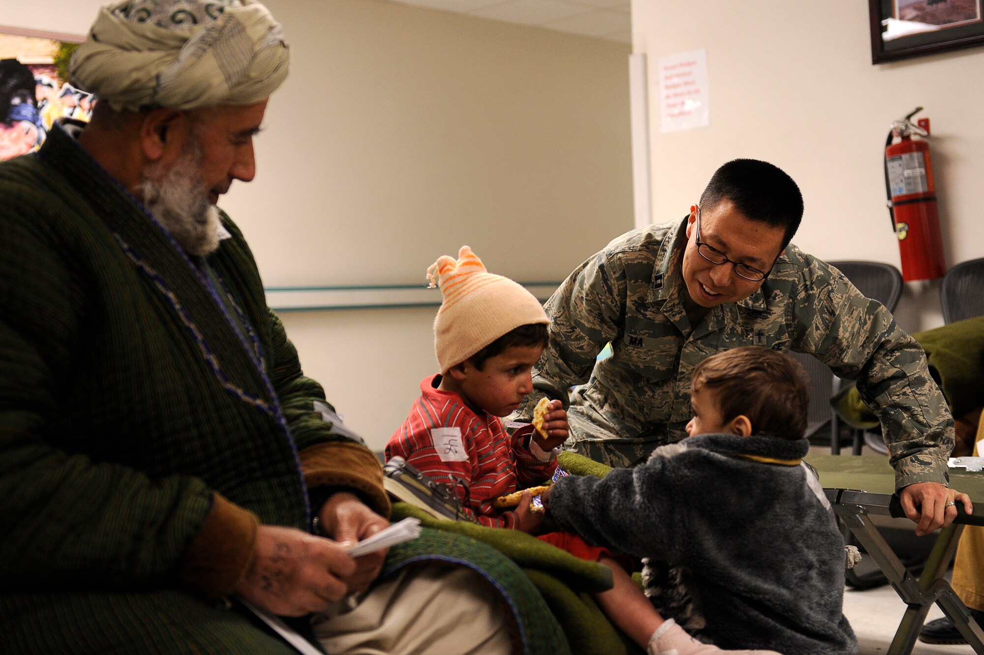 U.S. Air Force Chaplain (Capt.) Peter Ma, 455th Air Expeditionary Wing, talks with avalanche survivors who were medically evacuated to Craig Joint Theater Hospital, Bagram Airfield, Feb. 9, 2010. Dozens of Afghans were taken to Bagram Airfield after an avalanche struck a mountain pass in the Parwan province in north eastern Afghanistan. (U.S. Air Force photo by/ Tech. Sgt. Jeromy K. Cross/released)