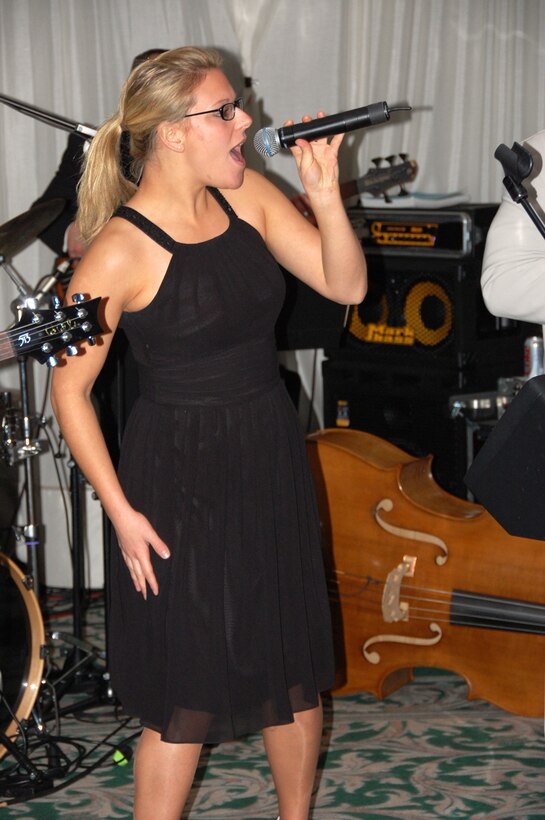 SrA Courtney Clifford sings with the popular music ensemble, Touch n' Go, for an audience in Italy.