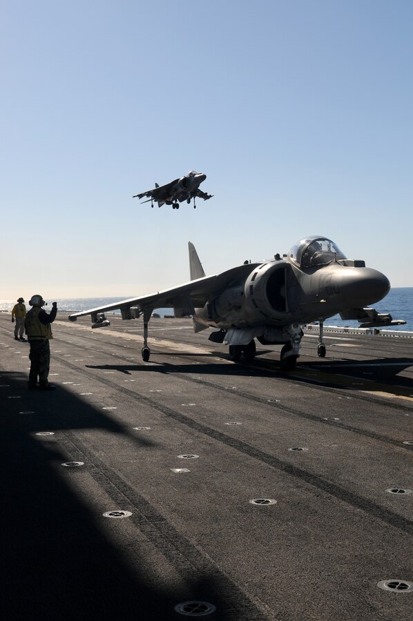 Maj. Jason Egan, Marine Attack Squadron 311 pilot, prepares to take off while Capt. Eric Fong, squadron pilot, lands behind him on the deck of the USS Peleliu in the Pacific Ocean Feb. 10, 2010. The squadron trained aboard the Peleliu for a week in order to obtain its aircraft carrier qualifications and prepare for its upcoming deployment in May. Approximately 10 pilots and 15 support and maintenance personnel participated in the exercise. The squadron practiced Harrier operations aboard the aircraft carrier from Feb. 8-11 in preparation for the squadron’s upcoming deployment aboard the Peleliu with the 15th Marine Expeditionary in May.