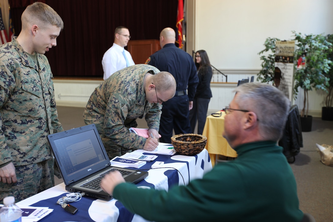 MARINE CORPS BASE CAMP LEJEUNE, N.C.-  Vernon Jeter (right), a human resources representative with WB Moore Company out of Charlotte, N.C., talks to Marines about job openings during the Employer Recruitment Day sponsored by Marine Corps Community Services, which was held Feb. 11. The event is the first of its kind held by MCCS.