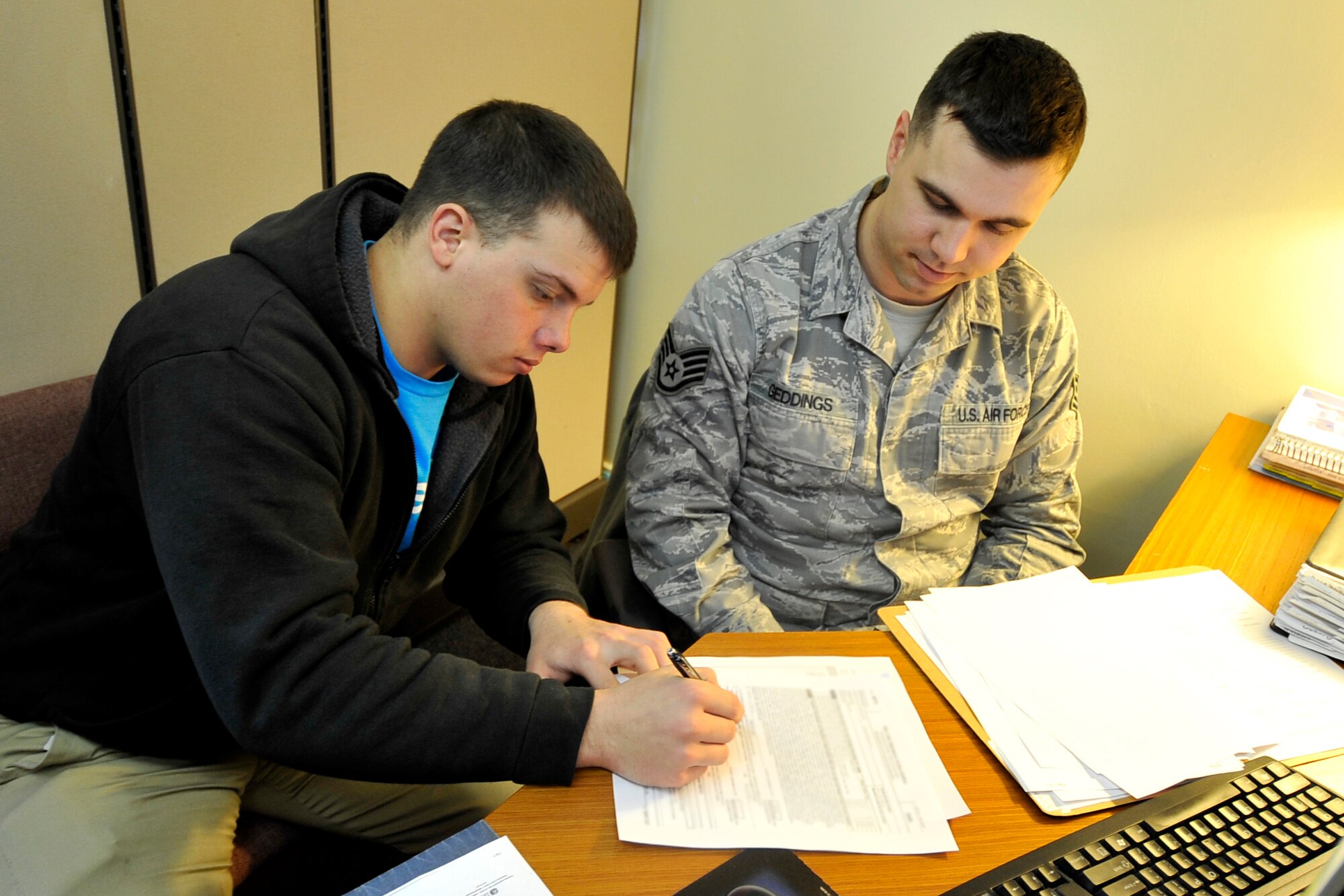 MISAWA AIR BASE, Japan -- Staff Sgt. Jason Geddings, tax center volunteer, helps Airman 1st Class David Cook, 35th Security Forces patrolmen, with his 2009 tax return Feb. 11. In 2008, the Misawa Tax Center saved individuals more than 200 thousand dollars in filing fees. (U.S. Air Force photo/Staff Sgt. Chad C. Strohmeyer)