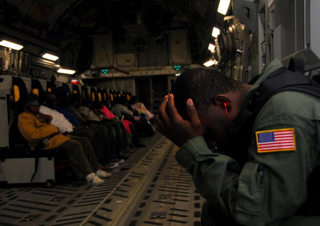 Staff Sgt. Anthony Clay rests his face in his hands just before takeoff aboard a C-17 in Port-au-Prince, Haiti, Feb. 6. The plane carried 75 evacuees scheduled to transit Charleston International Airport, with some having waited several weeks for a flight to the U.S. Sergeant Clay is a Phoenix Raven with the 628th Security Forces Squadron. (U.S. Air Force photo/Staff Sgt. Daniel Bowles)