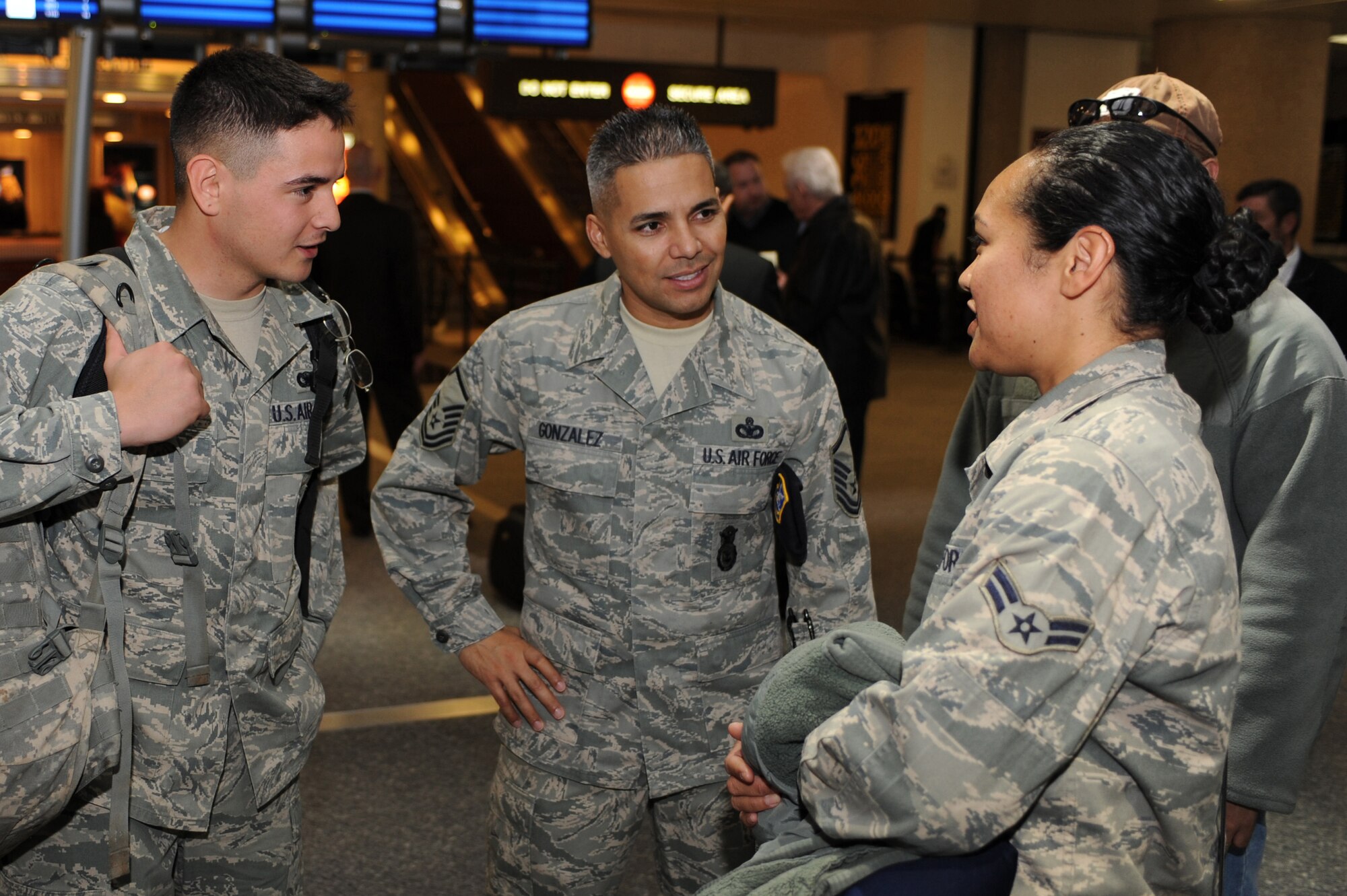 NELLIS AIR FORCE BASE, Nev.-- Senior Master Sgt. Gabriel Gonzalez talks with Senior Airman Jeremy Melvin and Airman 1st Class Tanja Kambel at McCarran International Airport after they returned from a deployment.  Approximately 25 members of the 99th Security Forces Squadron returned Jan. 31 from a deployment to Southwest Asia.  (U.S. Air Force photo by Tech. Sgt. Langford Saturnio)