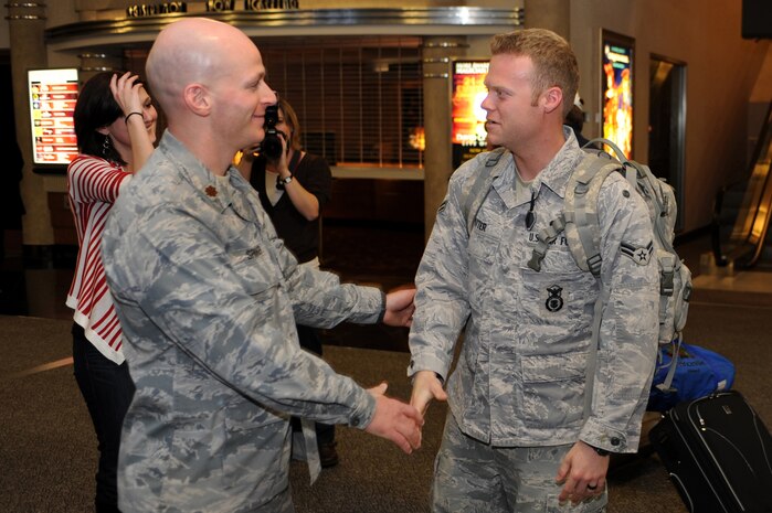 NELLIS AIR FORCE BASE, Nev.-- Maj. Eric Springer, commander of the 99th Security Forces Squadron, greets Airman 1st Class Talon Potter at the airport after returning from a deployment.  Approximately 25 members of the 99th SFS returned Jan. 31 from a deployment to Southwest Asia.  (U.S. Air Force photo by Tech. Sgt. Langford Saturnio)