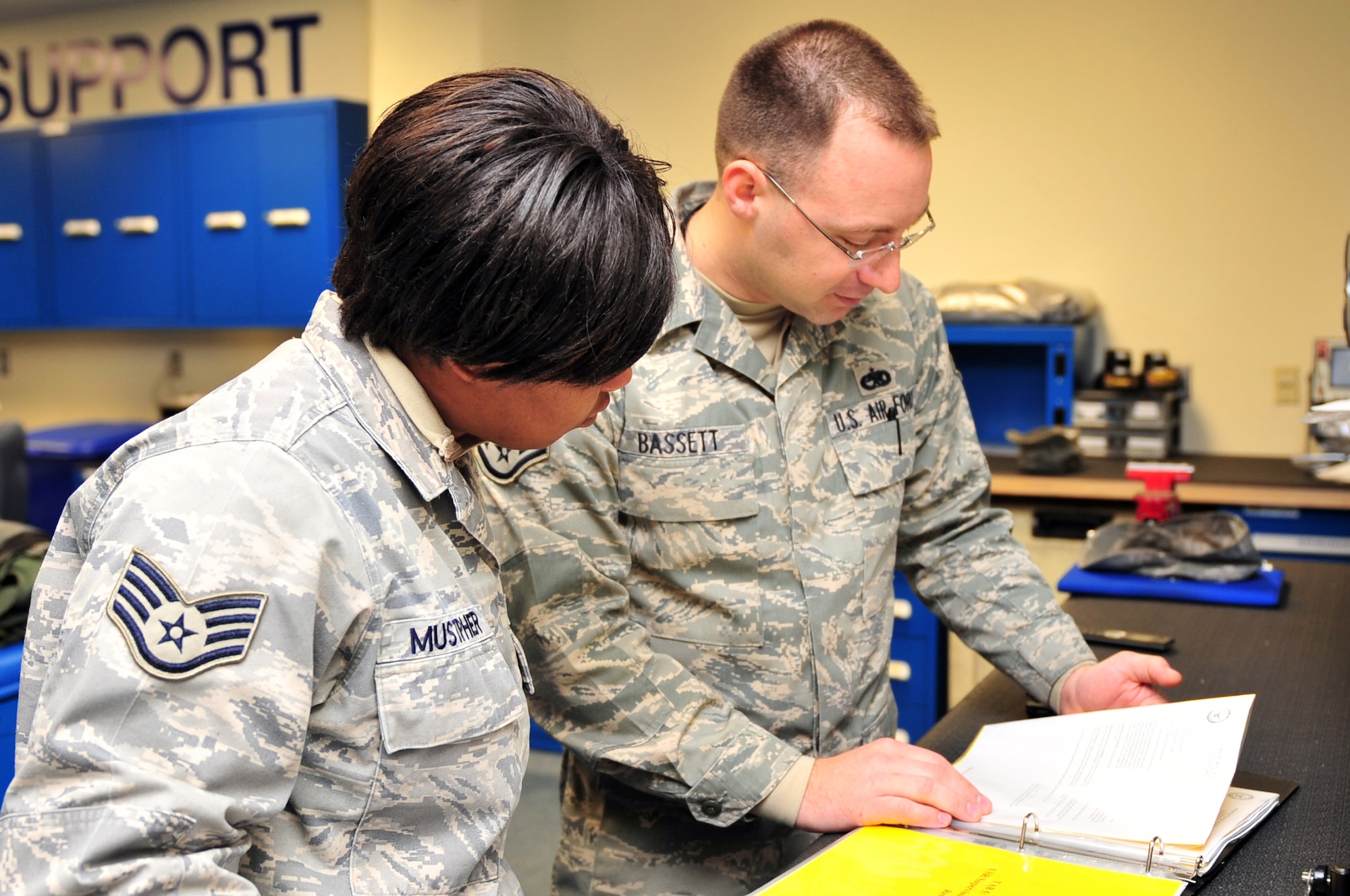 Staff Sgt. Shaun Bassett, 4th Fighter Wing ground safety apprentice, quizzes Staff Sgt. Beverly Mustipher, 4th Operations Support Squadron aircrew flight equipment craftsman, how to use a lockout-tagout log in the 334th Fighter Squadron's life support section on Seymour Johnson Air Force Base, N.C., Feb. 9, 2010. When locking a piece of equipment from use, certain procedures are taken to ensure it cannot inadvertently start. The procedures are noted in the log for future reference.  (U.S. Air Force photo/Senior Airman Rae Perry)