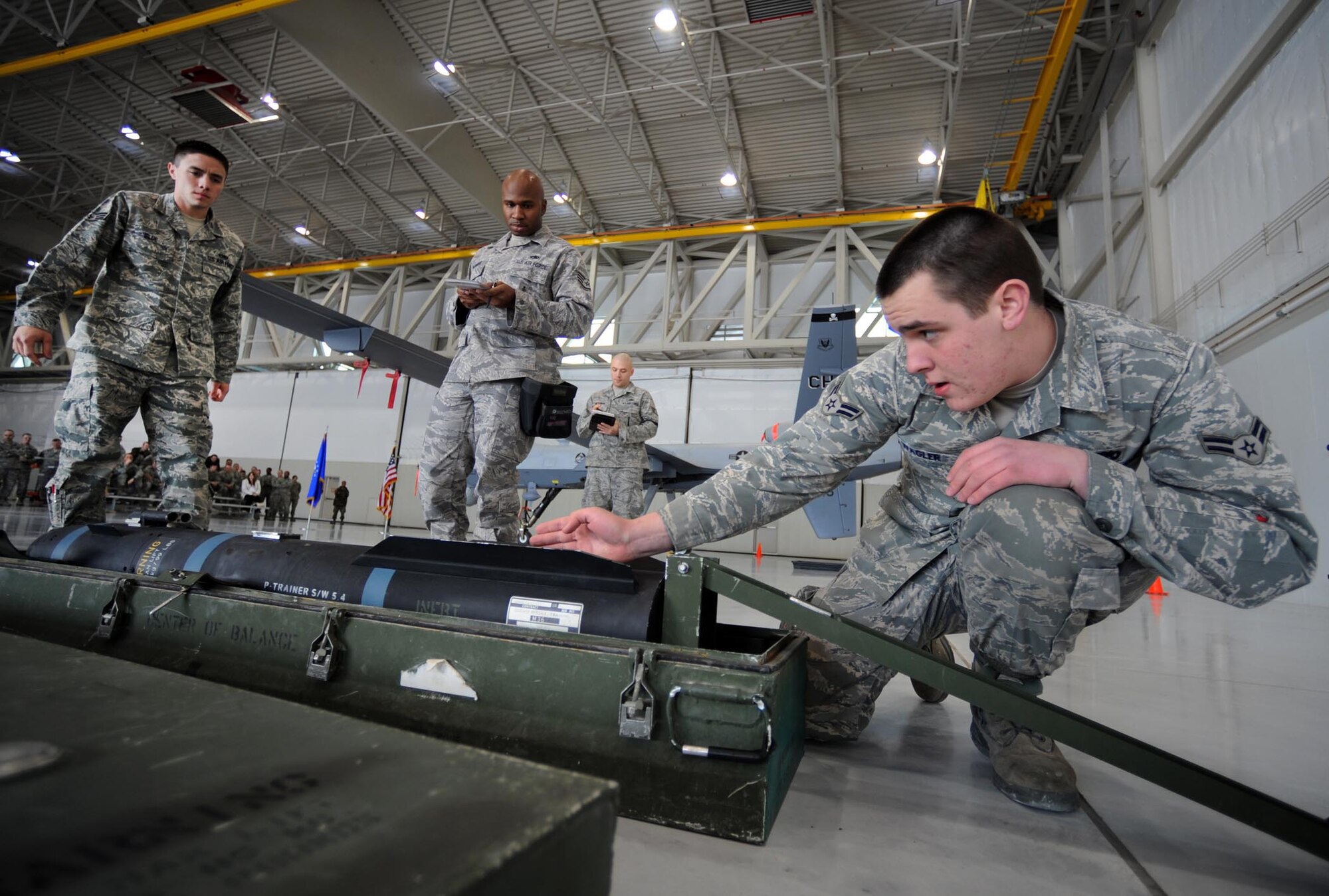 CREECH AIR FORCE BASE, Nev. --  Airman 1st Class Shane Wagler and Senior Airman Terry Blue, inspect an inert AGM-114 Hellfire II air-to-ground missile while Staff Sgt. Roddrick Palmore, writes down missle discrepancies during the 432d Aircraft Maintenance Squadron load crew of the year competition here recently. Airmen Wagler and Blue, and Sergeant Rodderick, are MQ-9 Reaper weapons loaders assigned to the 432d AMXS. (U.S. Air Force photo by Tech. Sgt. Michael R. Holzworth)