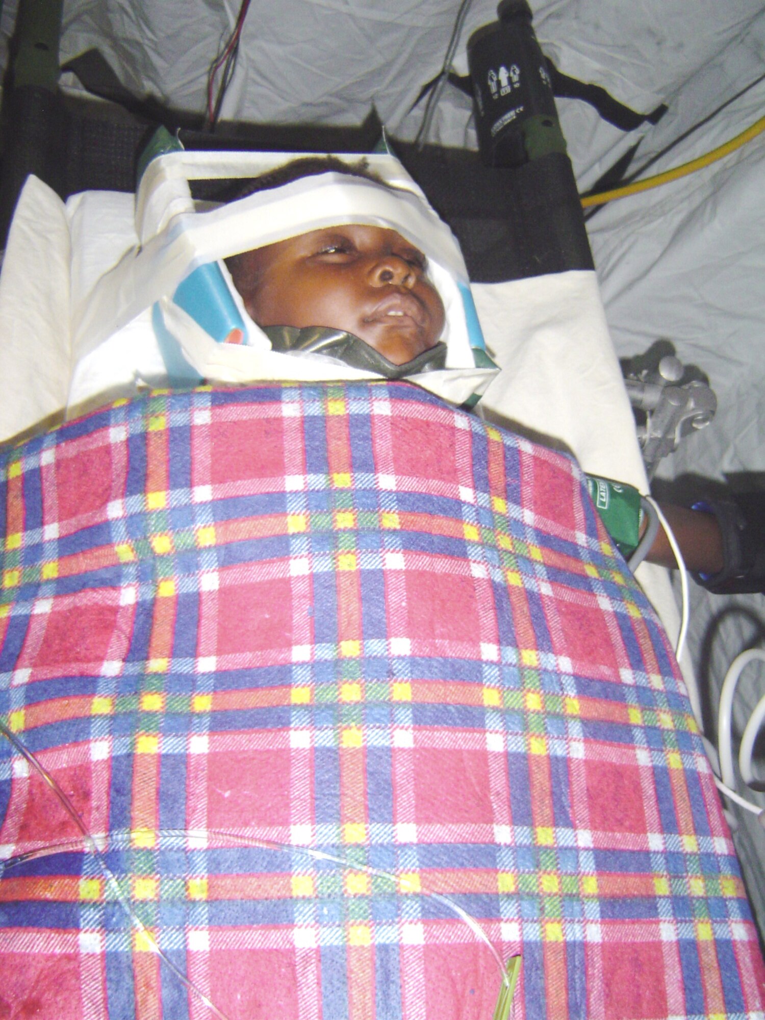 A 4-year-old girl with a cervical fracture and spinal cord injury had her neck immobilized by a critical care air transport team from Keesler Air Force Base, Miss., during a C-130 Hercules flight from Haiti to a medical facility in Florida Feb. 7, 2010. Keesler AFB CCAT teams are providing medical care to victims of the Haiti earthquake who are airlifted to hospitals in the United States. (U.S. Air Force photo/Maj. (Dr.) Stephen Boskovich)