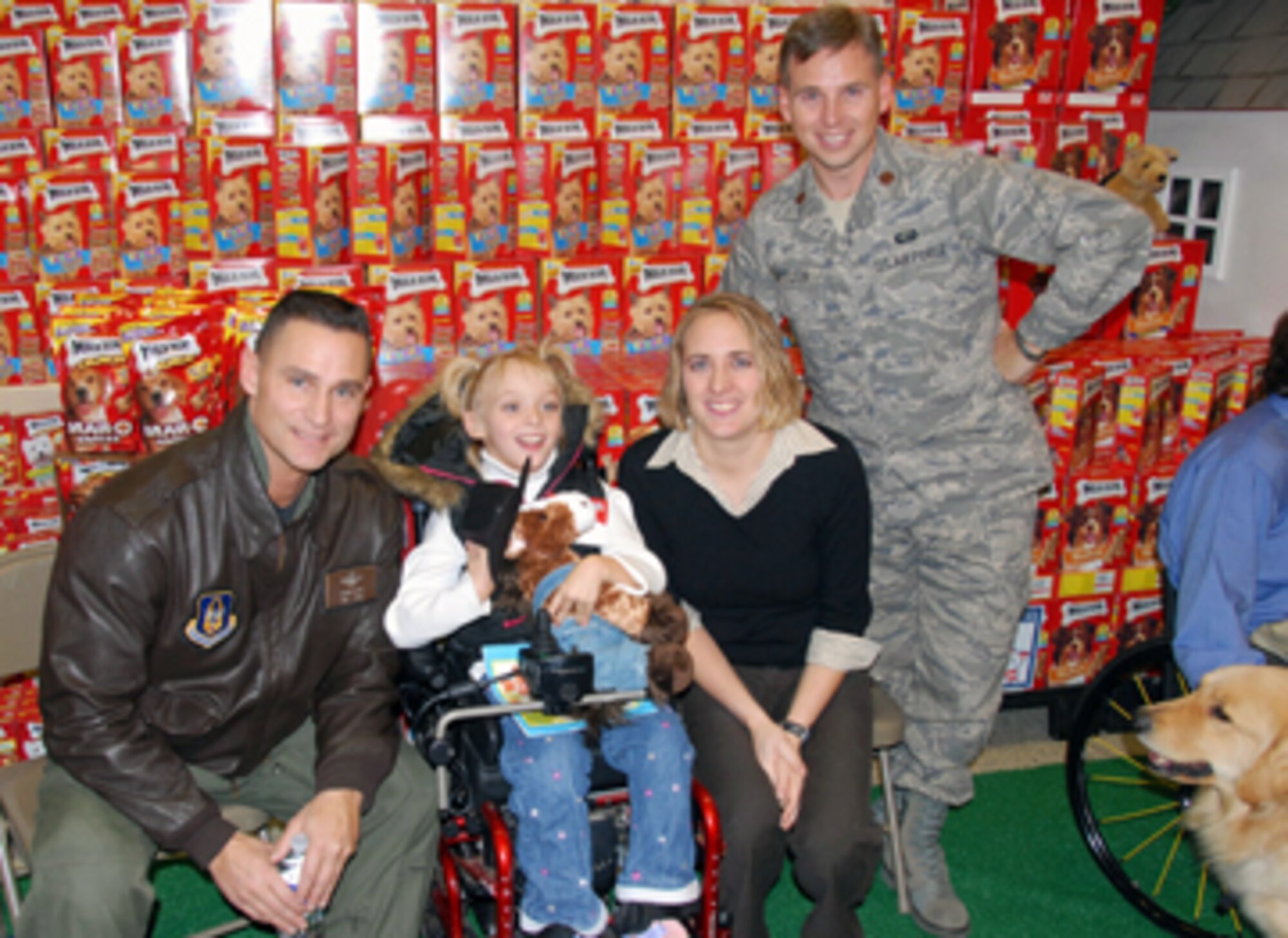 Colonel Brett Clark, commander of the 908th Airlift Wing, left, poses for a photo with Alexis Butler and her parents, Majors Todd and Sarah Butler, commander of the 908 Mission Support Flight. The 10-year-old, who has cerebral palsy, was recently selected to receive a helping dog through a combined effort of the Defense Commissary Agency, Milk-Bone and Canine Assistants. Sometime this summer, Alexis will take part in a special camp where she will be specially matched with her dog. The pair will then undergo two weeks of training after which the canine will assist Alexis so she won't be as dependent upon her walker.