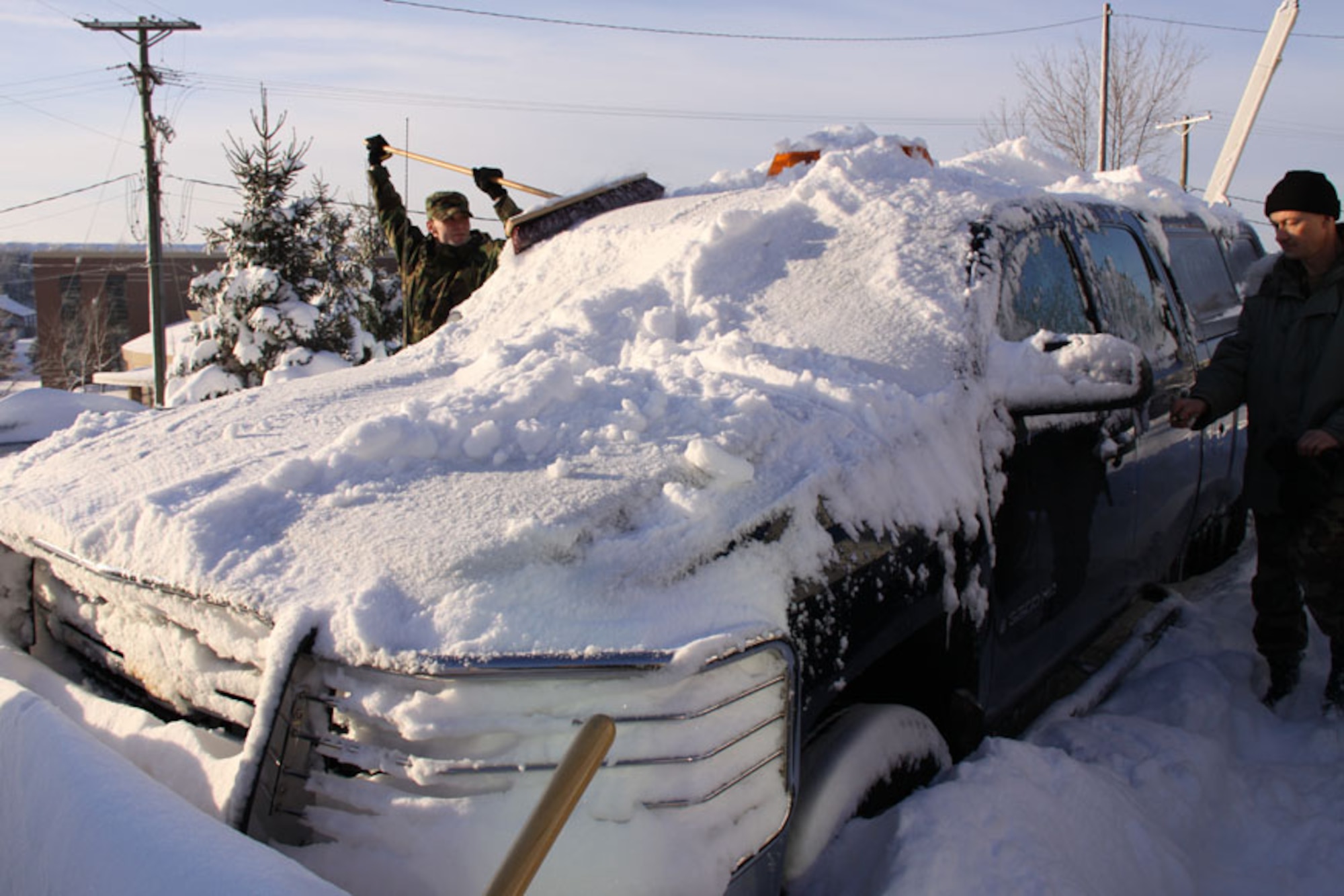 Senior Airman Steven Collins and Master Sgt. Tom Borst, 911th Airlift Wing safety office, remove snow from the wing safety truck after a major snowstorm disrupted planned unit training activities, Feb. 6 - 7, 2010.
