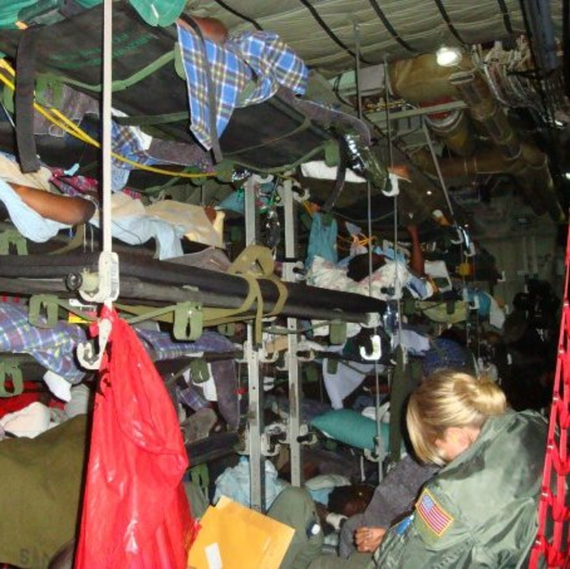 A CCATT member, lower right, sits among litter patients being transported on an Air Force C-130.  Major Boskovich said their highest tempo of missions were the daily ones to Haiti, “with as many litter patients as we could fit on the plane (20-30) and four to five critical patients attended by the CCATT team.”  (Courtesy photo)
