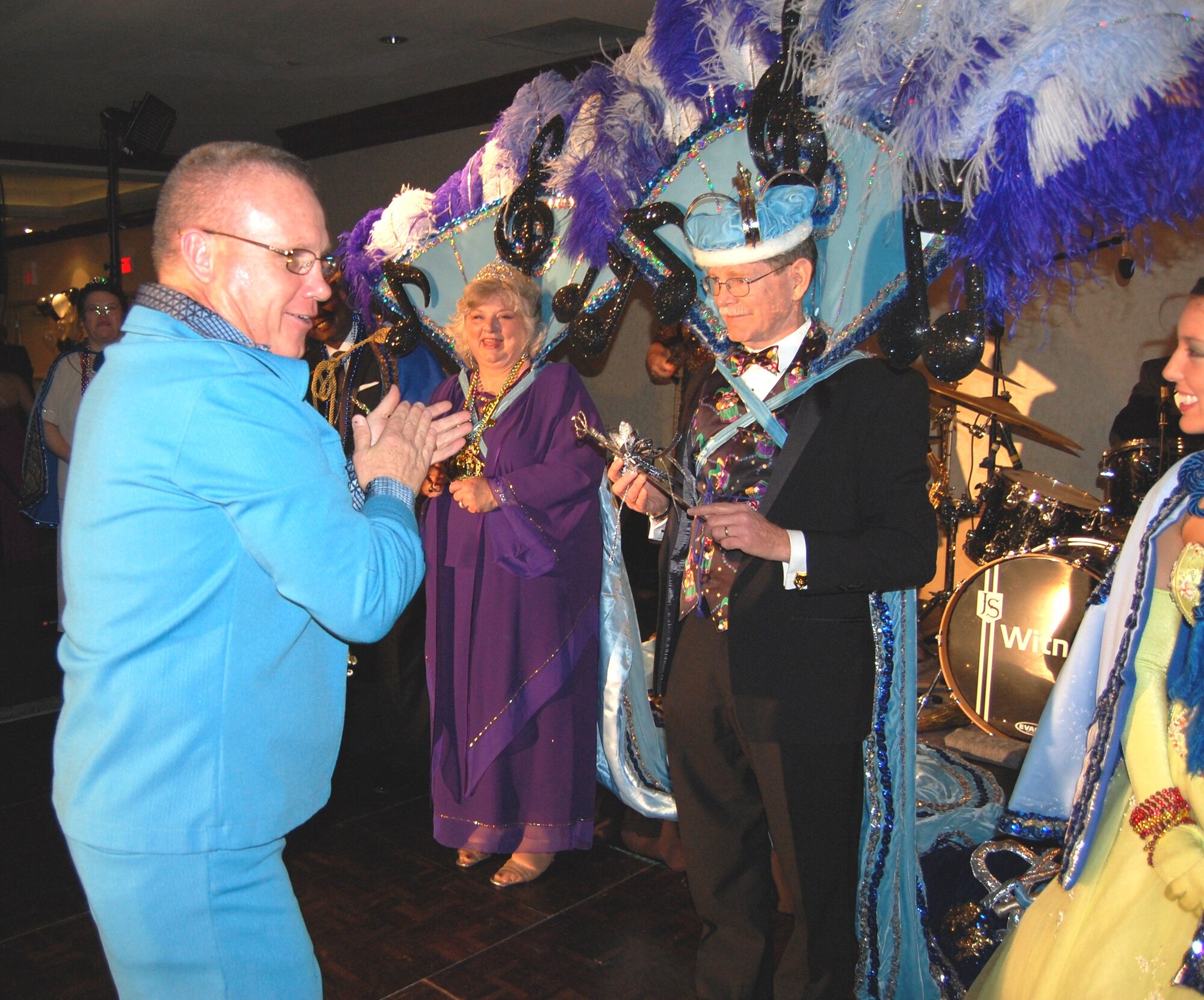 Brig. Gen. Dan Wyman, left, 81st Medical Group commander, leads the applause for the royalty of the 22nd annual Krewe of Medics Mardi Gras ball Saturday — Queen Kay Hymel and King Walt Brehm.  In keeping with this year’s theme, “Music, Music, Music,” General Wyman wore a blue leisure suit and platform shoes reminiscent of the 60’s disco scene, Mrs. Hymel represented Barbra Streisand and Mr. Brehm represented Sir Paul McCartney.  Mrs. Hymel is General Wyman’s secretary, and Mr. Brehm is the statistician at the 81st Medical Support Squadron’s clinical research laboratory.  (U.S. Air Force photo by Kemberly Groue)