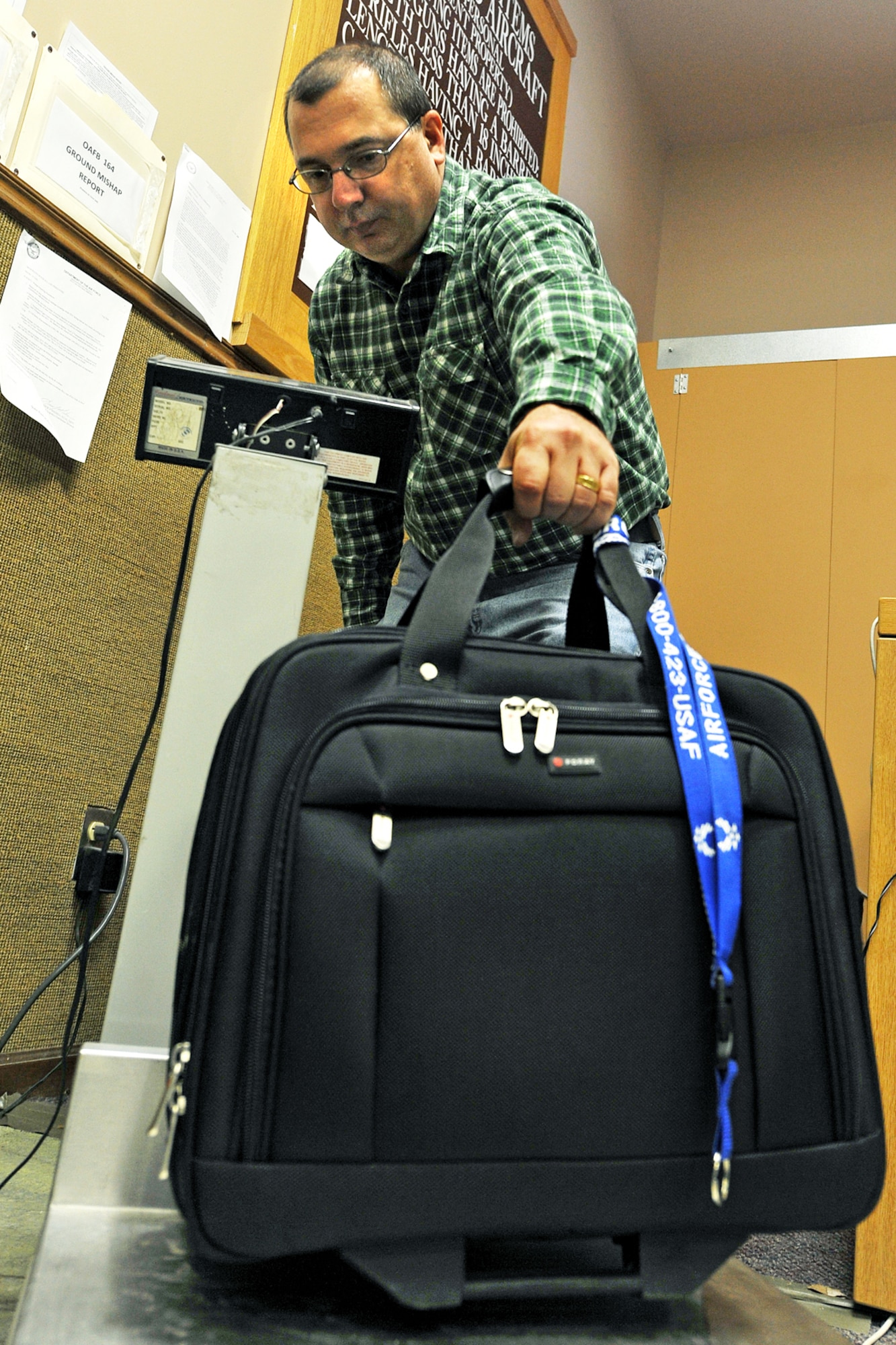 OFFUTT AIR FORCE BASE, Neb. -- Tom Kovy, logistics management specialist with the 55th Mission Support Group, weighs a piece of luggage at the passenger terminal here Feb. 11. Space-available flights for military members, family members, and military retirees to places such as Peterson AFB, Colo., Scott AFB, Ill., and Andrews AFB, Md., are available from Offutt. 

U.S. Air Force photo by Charles Haymond