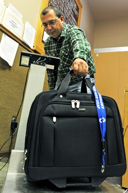 OFFUTT AIR FORCE BASE, Neb. -- Tom Kovy, logistics management specialist with the 55th Mission Support Group, weighs a piece of luggage at the passenger terminal here Feb. 11. Space-available flights for military members, family members, and military retirees to places such as Peterson AFB, Colo., Scott AFB, Ill., and Andrews AFB, Md., are available from Offutt. 

U.S. Air Force photo by Charles Haymond
