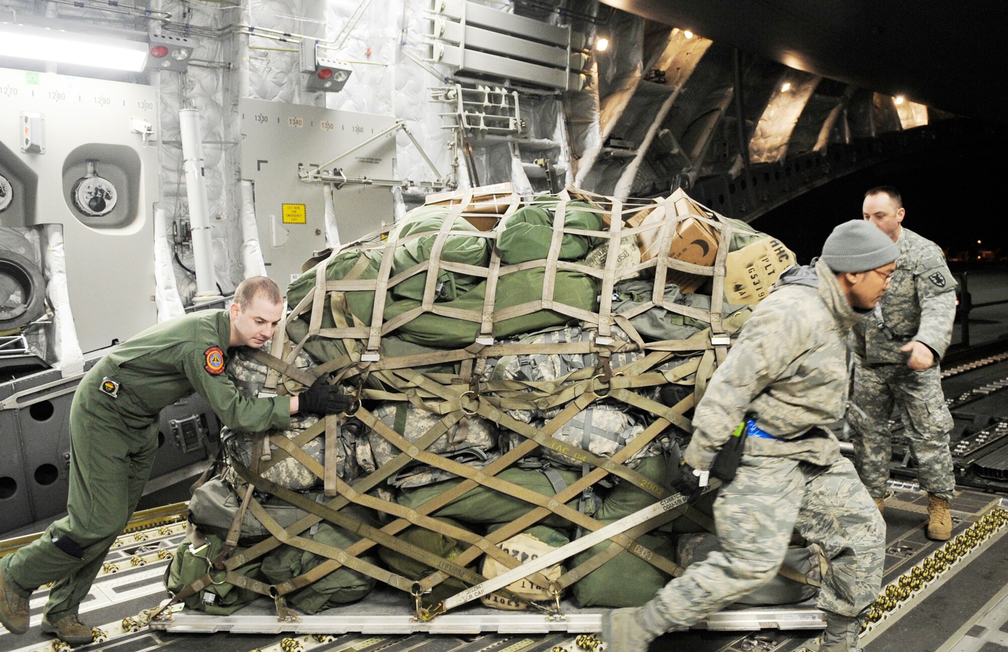 Airmen and Soldiers load cargo onto a C-17 Globemaster III Feb. 8, 2010, at Langley Air Force Base, Va. Through a joint effort by Soldiers and Airman from Joint Base Langley-Eustis, servicemembers and cargo are transported to Haiti as part of Operation Unified Response. (U.S. Air Force photo/Senior Airman Dana Hill)
