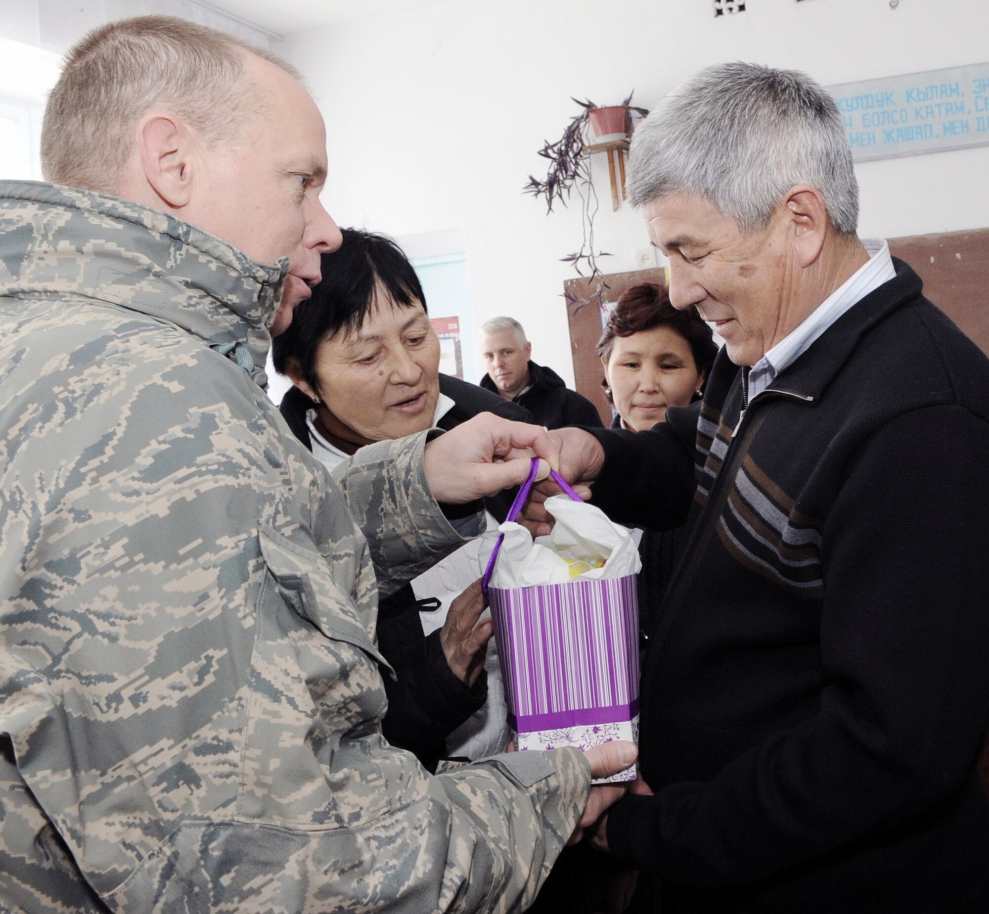 Gen. Donald J. Hoffman presents Syrgak Kyolykeer with a gift from the Transit Center at Manas, Kyrgyzstan Feb. 9, 2010, at the Grozd School in Grozd Village, Kyrgyzstan. General Hoffman is the commander of the Air Force Materiel Command and Mr. Kyolykeer is the mayor and head for the Grozd Village administration. (U.S. Air Force photo/Senior Airman Nichelle Anderson)